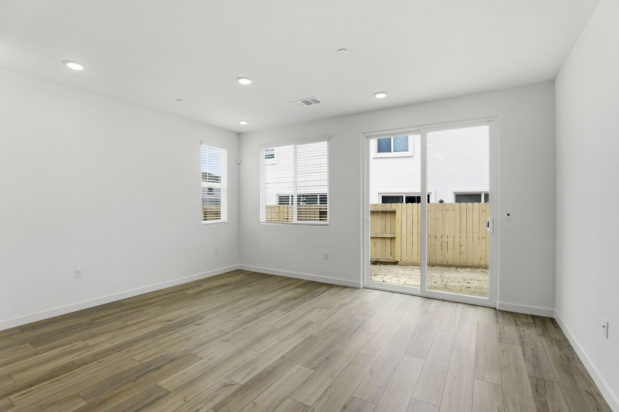 A room with a wood floor and a wood floor with a door.