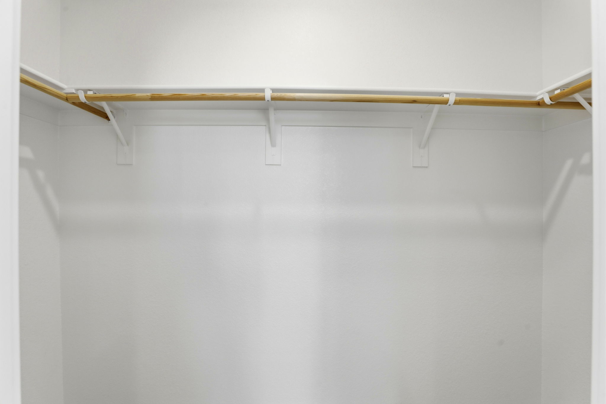 A white wall with a wooden bar.