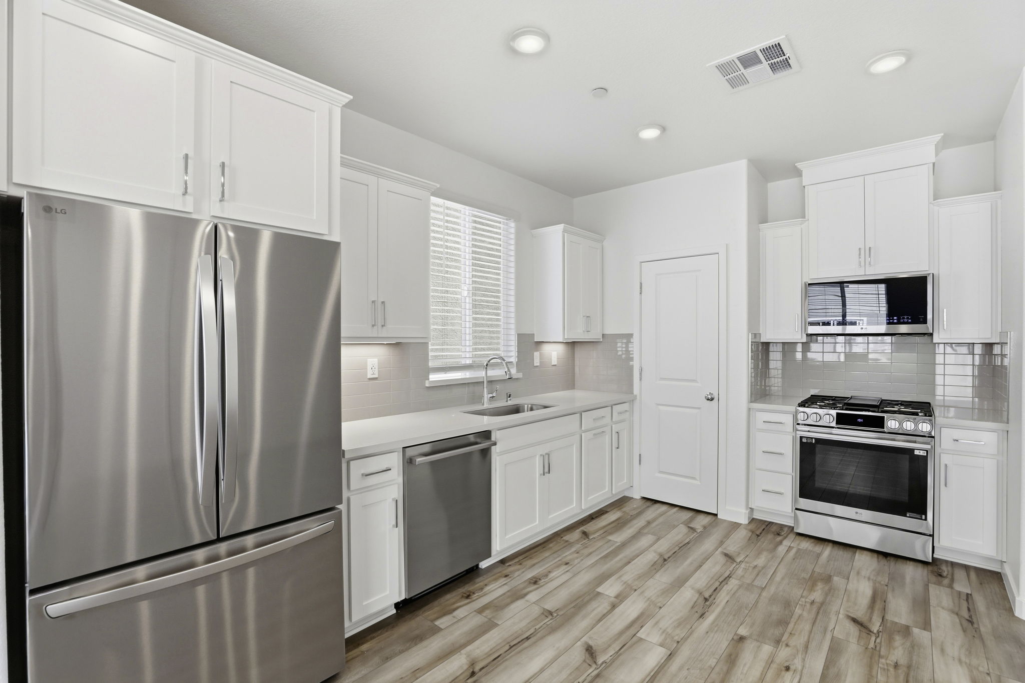 A kitchen with white cabinets.