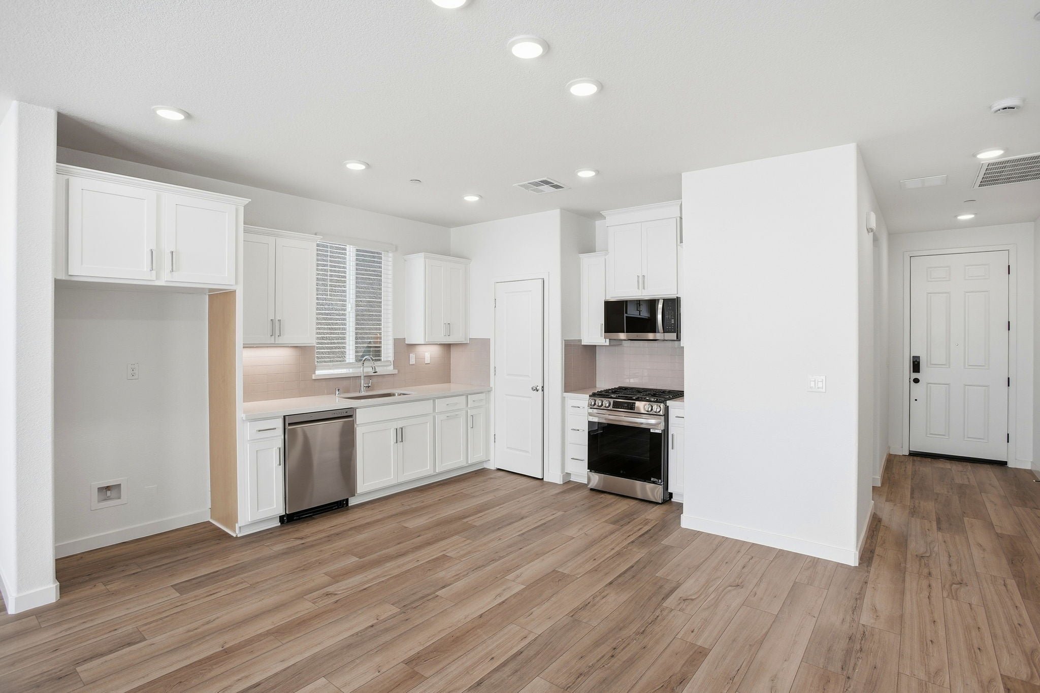 A kitchen with white cabinets.