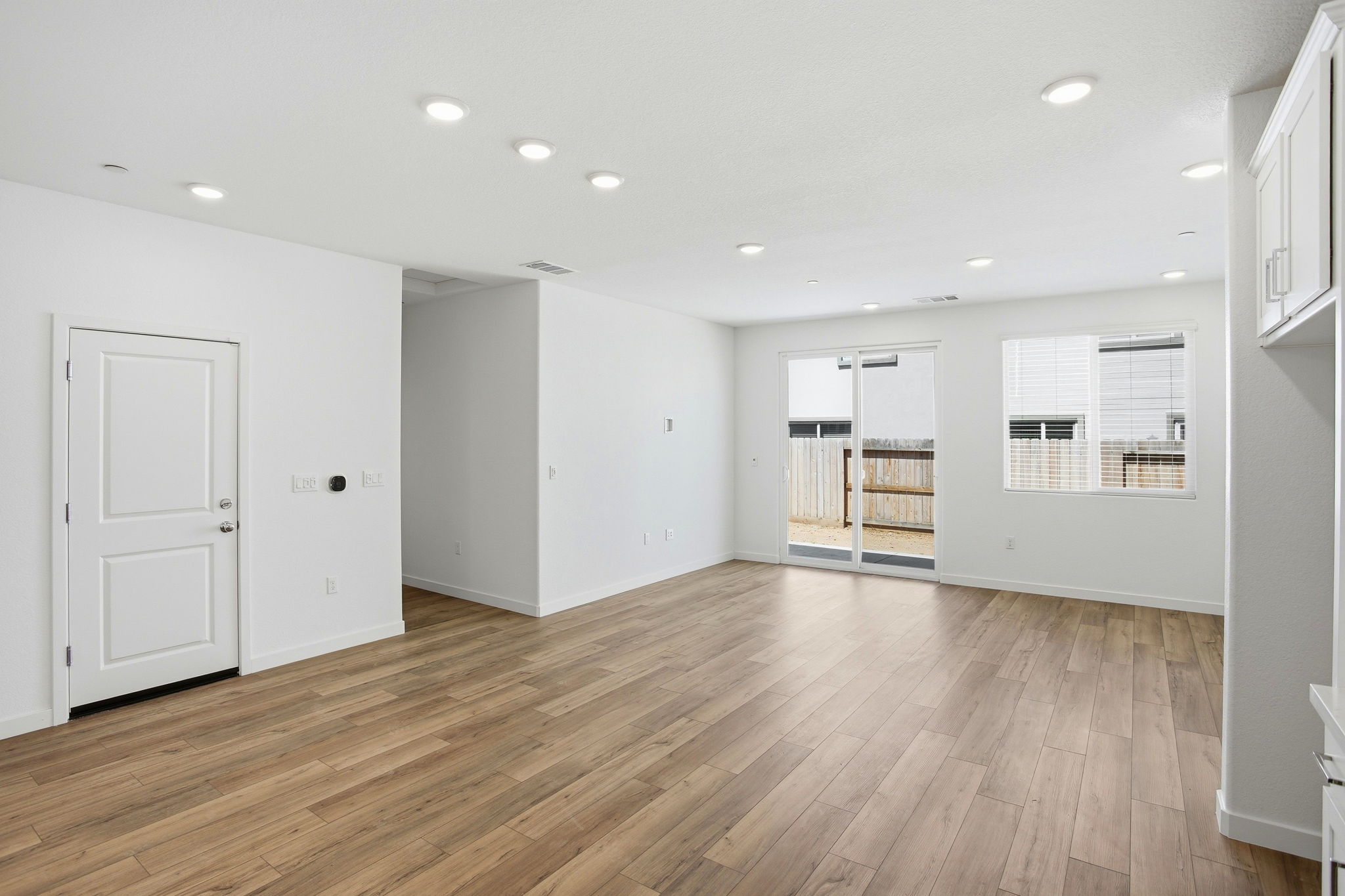 A room with white walls and wood floors.