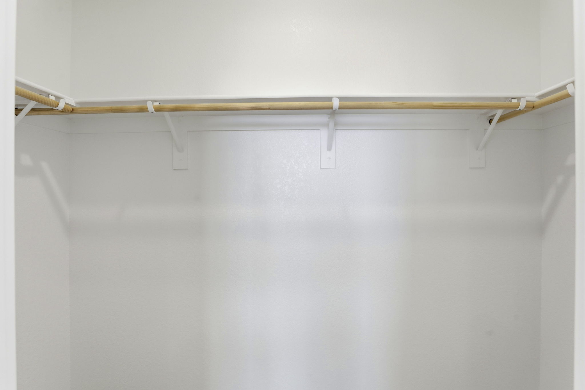 A white wall with a wooden bar.