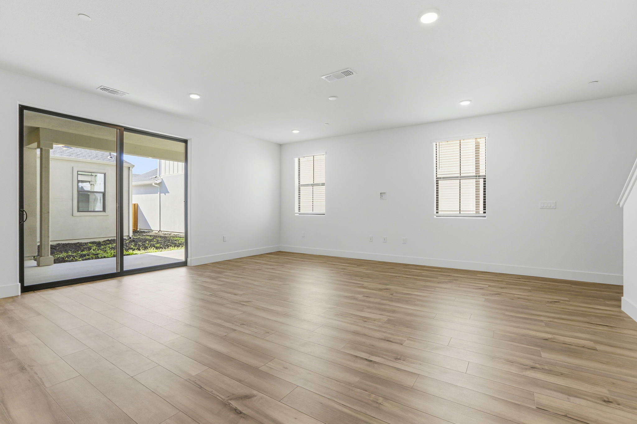 A room with a wood floor and a large glass door.