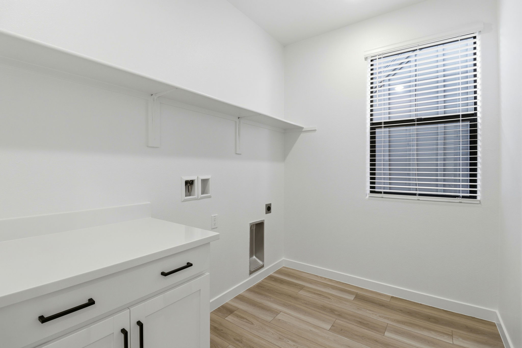 A white kitchen with a window.