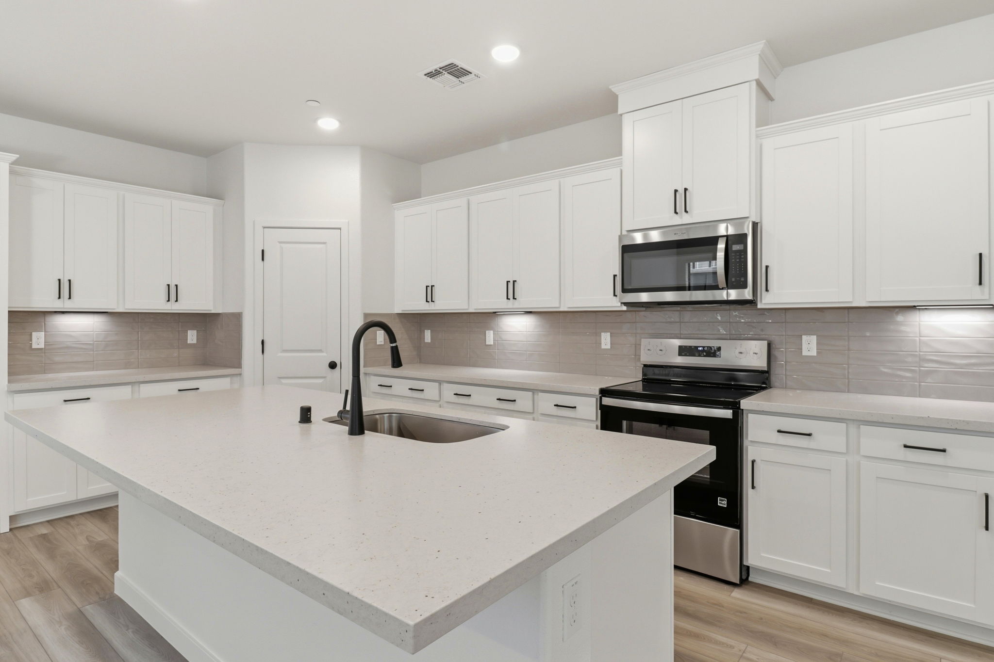 A kitchen with white cabinets.