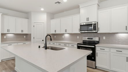 A kitchen with white cabinets.