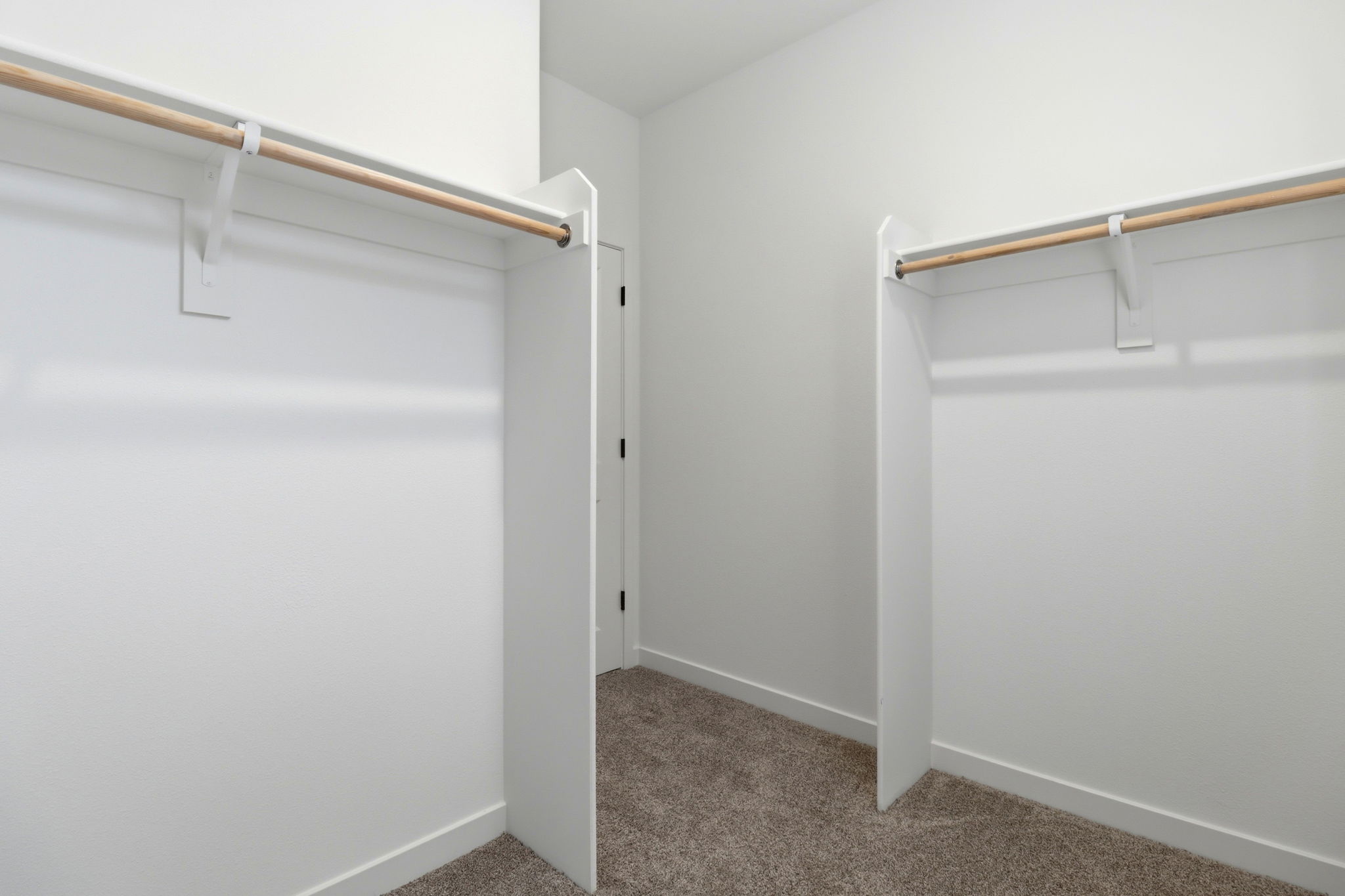 A white wall with a metal bar.