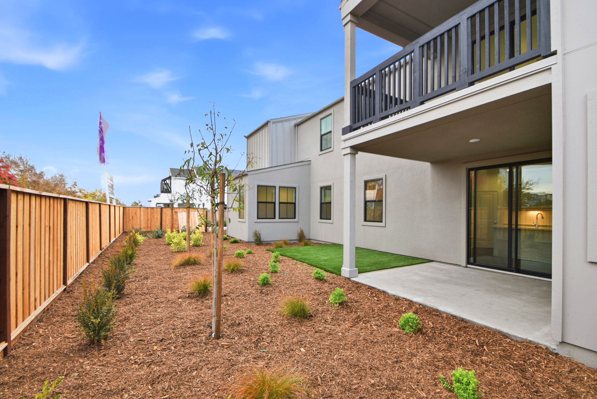 A building with a fence and a tree in front.
