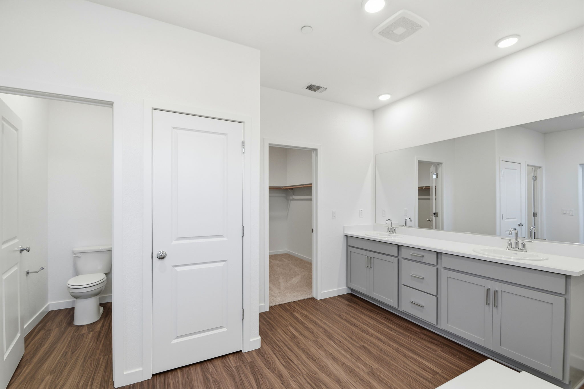 A bathroom with white cabinets.