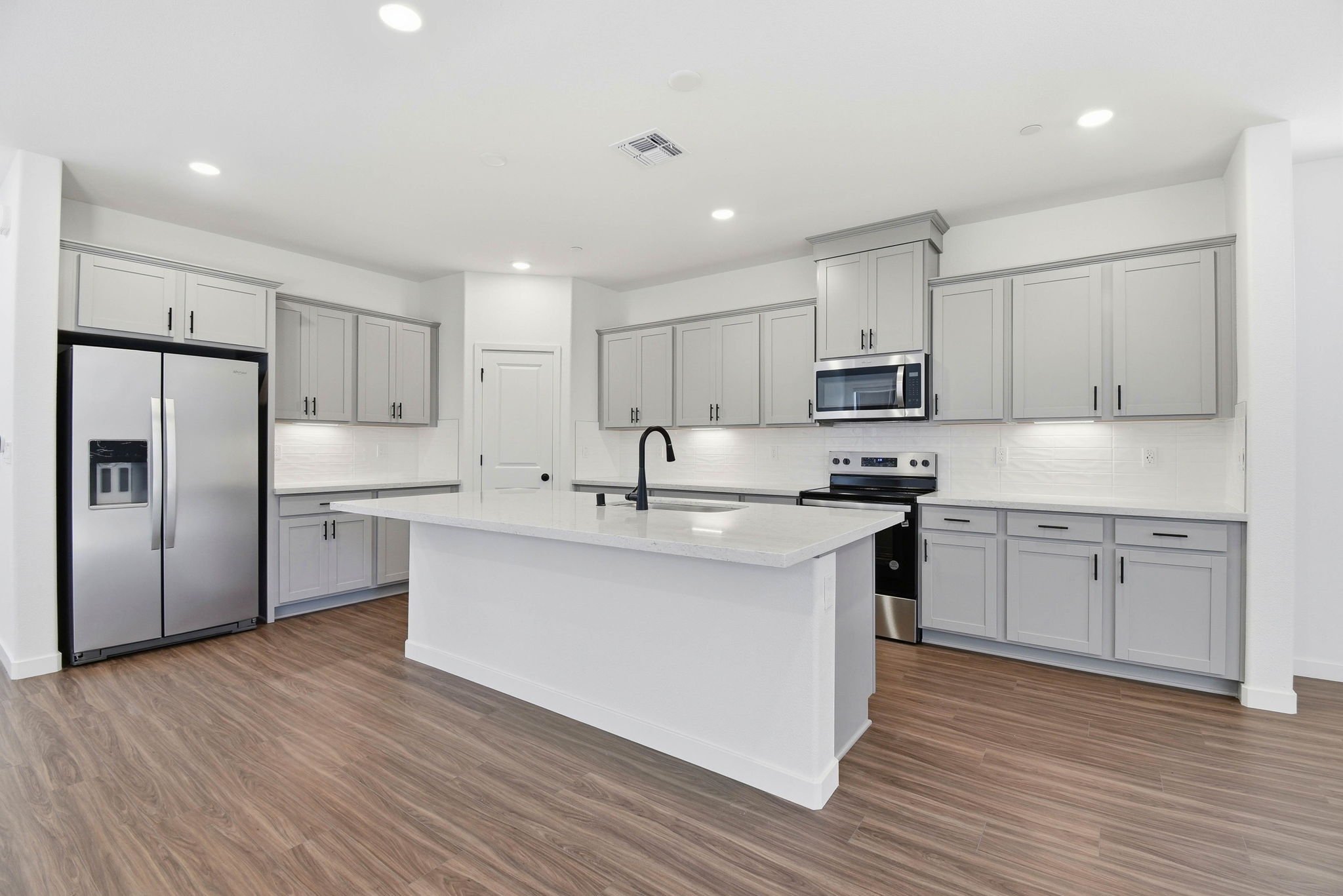 A kitchen with white cabinets.