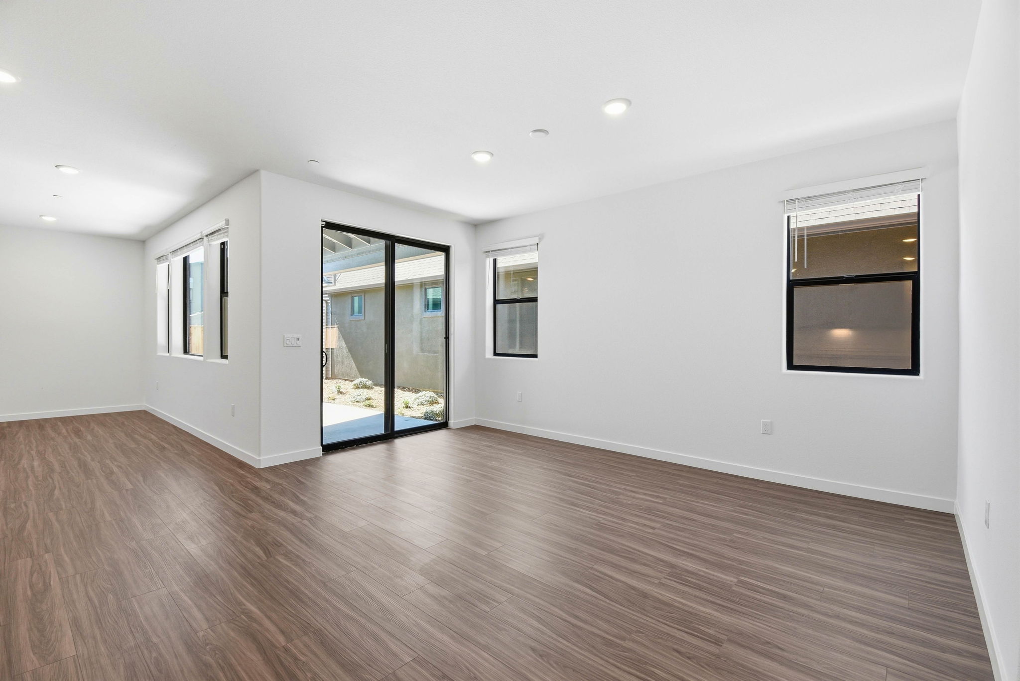 A room with a wood floor and a wood floor with a glass door.