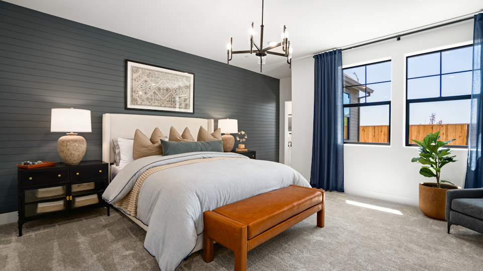 A bedroom with a bed and a bench.