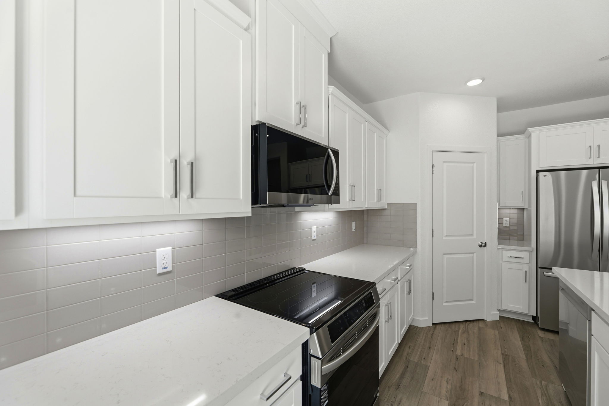 A kitchen with white cabinets.