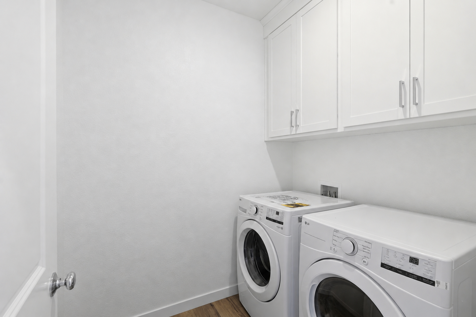 A white laundry room with a washing machine and dryer.
