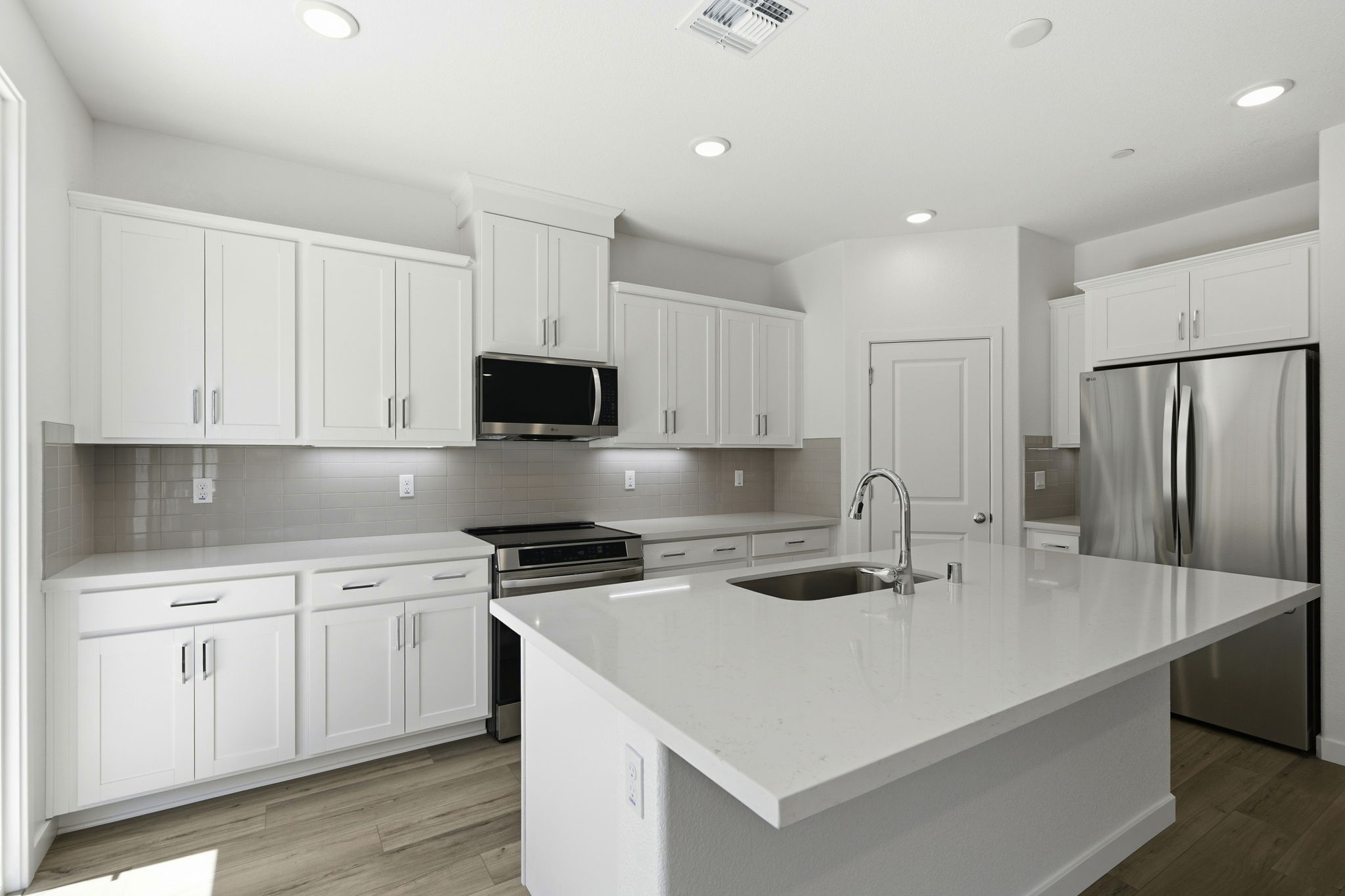 A kitchen with white cabinets.