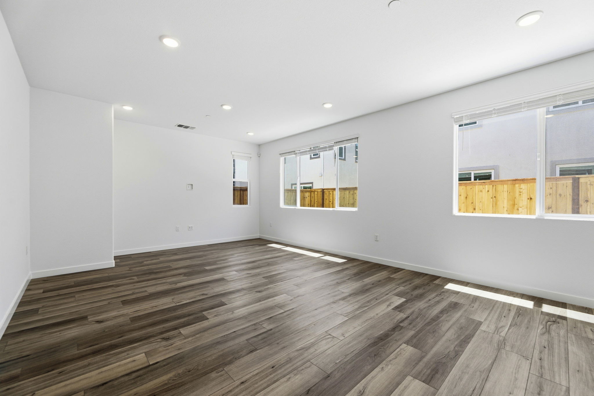 A room with a wood floor and white walls.