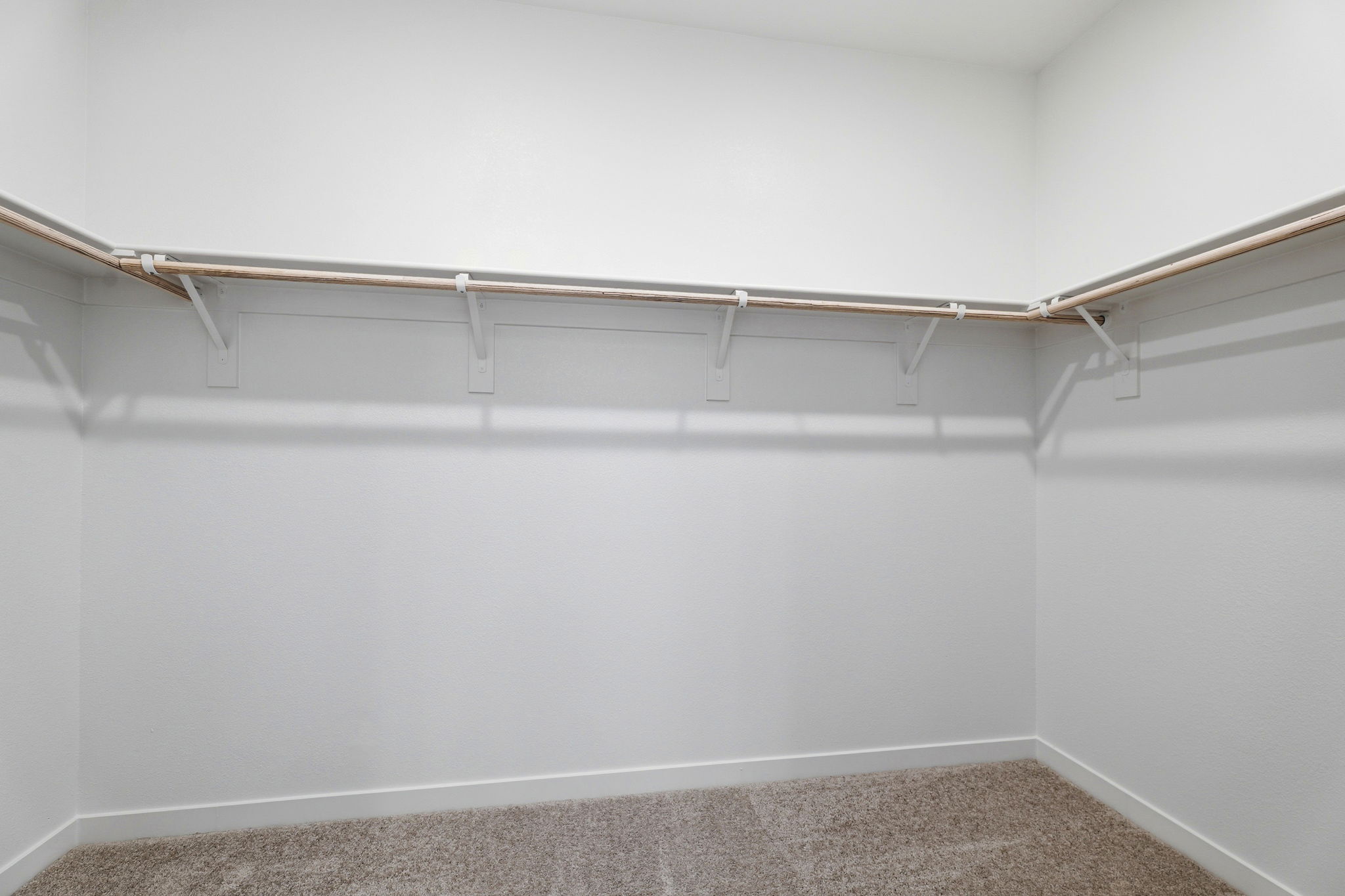 A white wall with a metal bar.