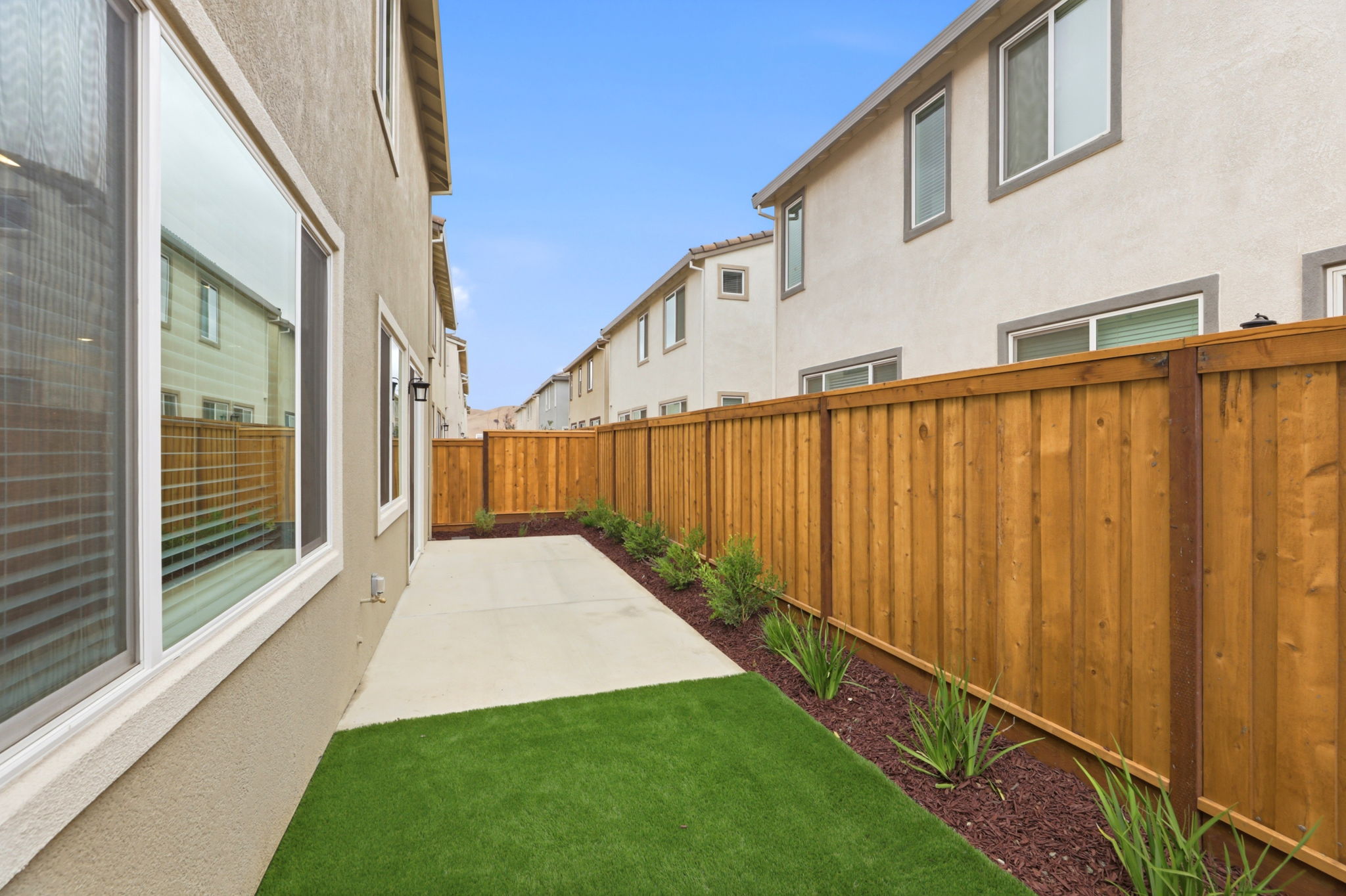 A backyard with a fence and a house.