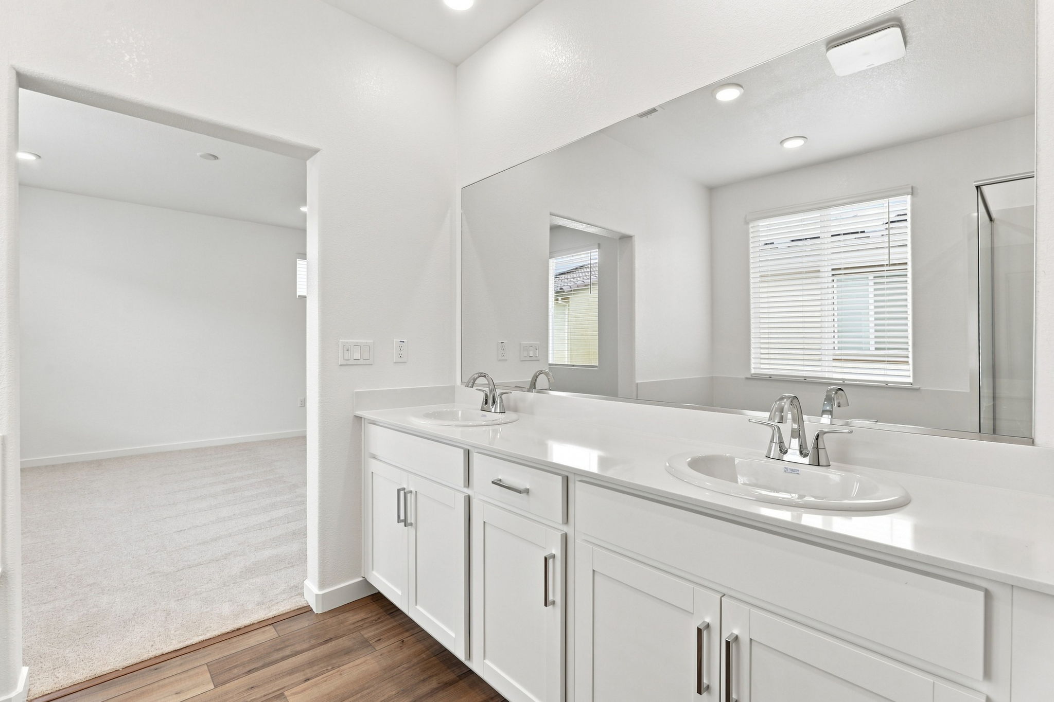 A bathroom with white cabinets.