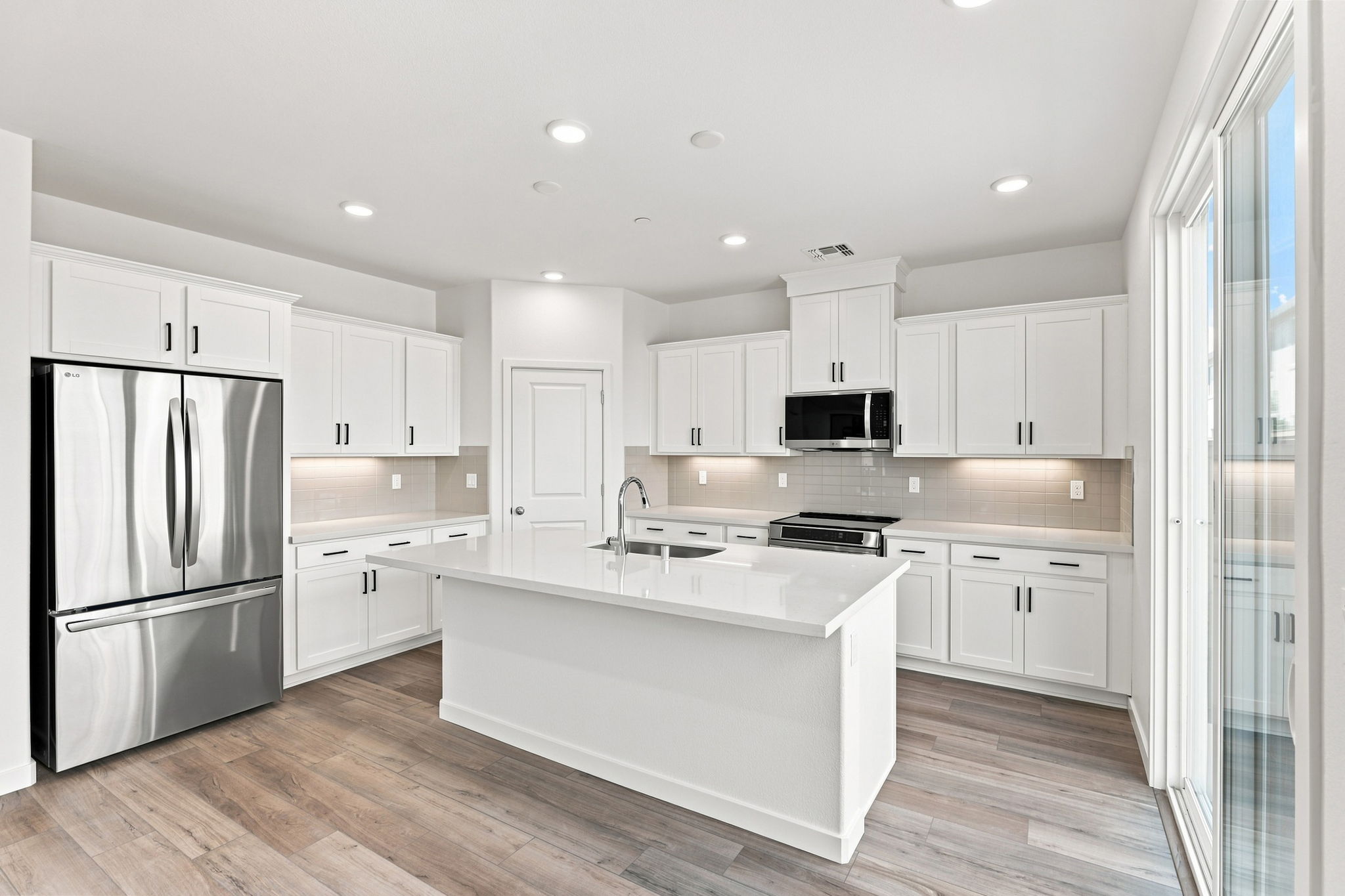 A kitchen with white cabinets.