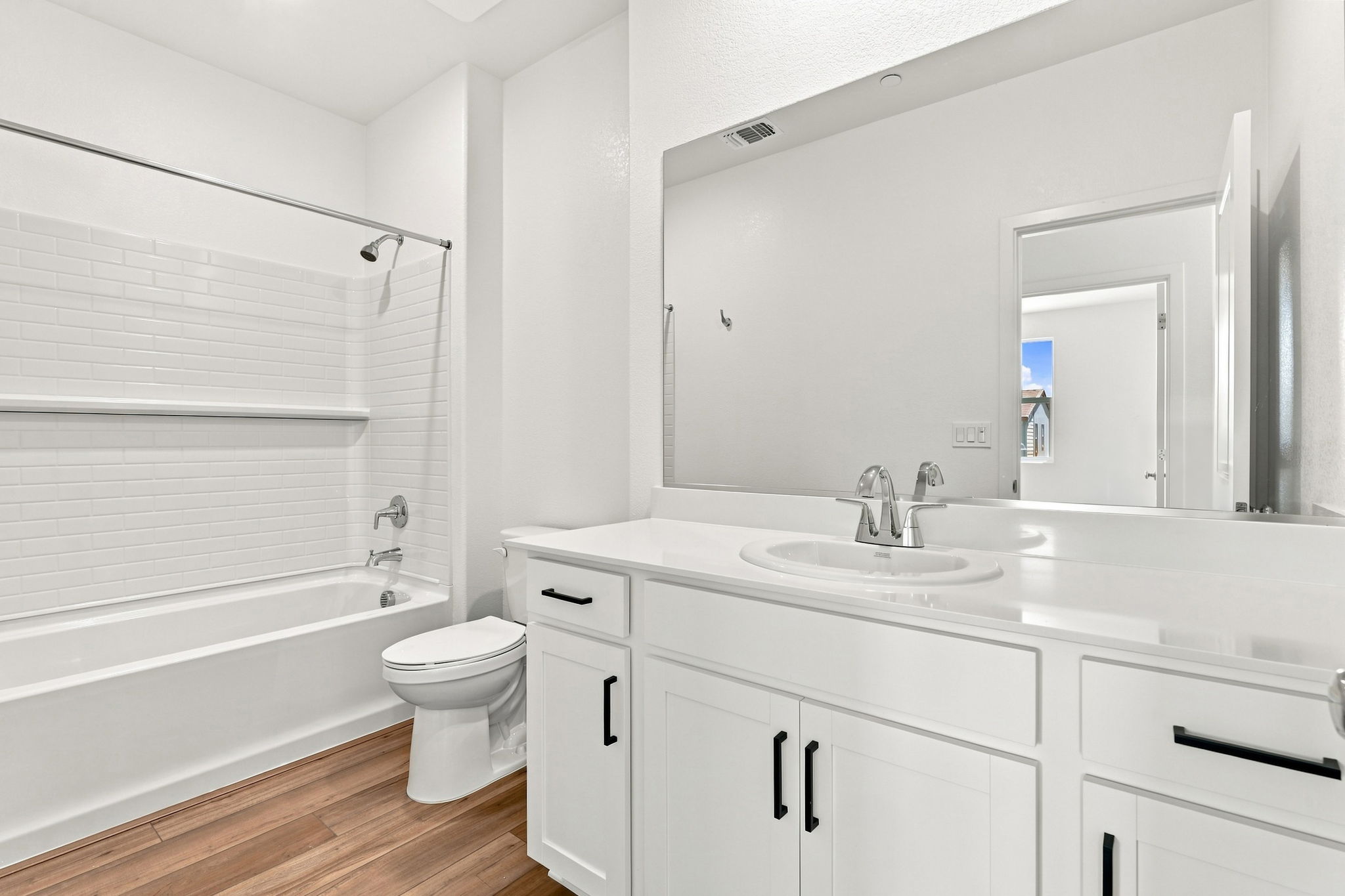 A bathroom with white cabinets.