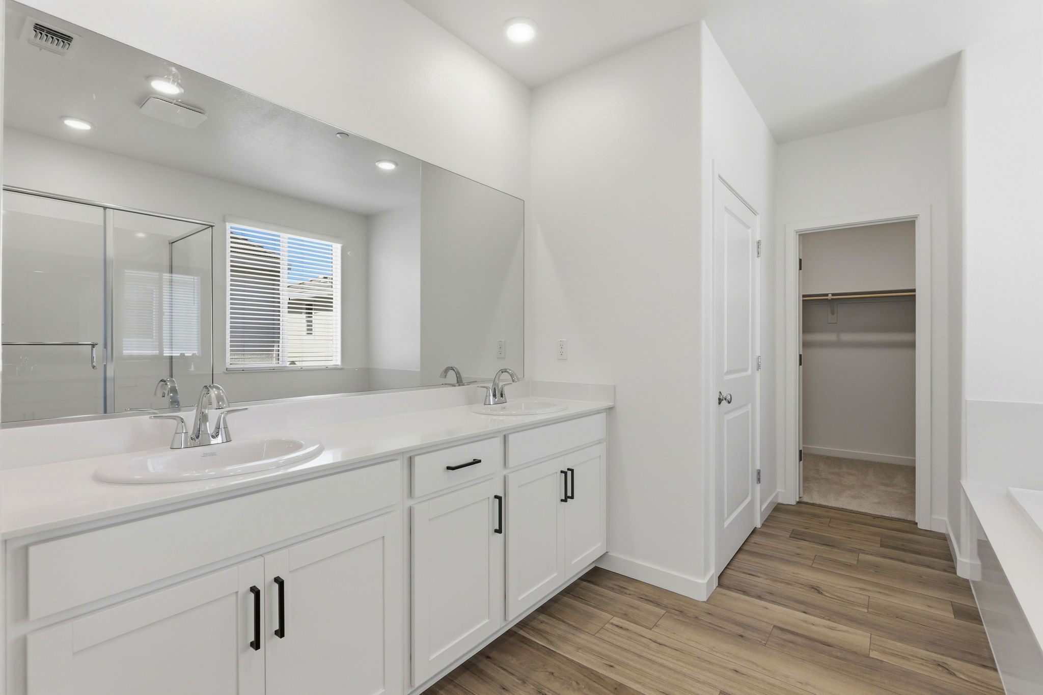 A bathroom with white cabinets.