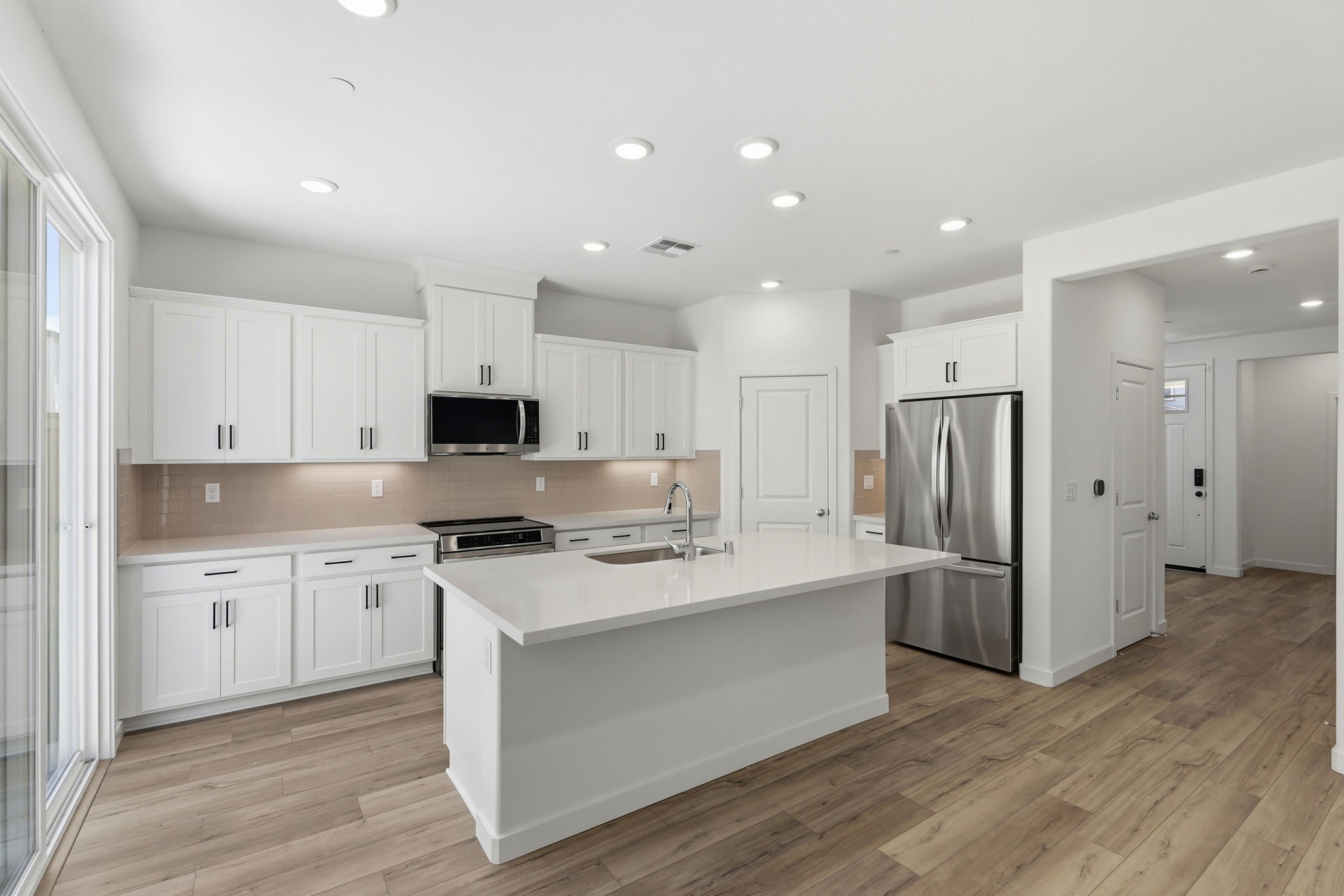 A kitchen with white cabinets.