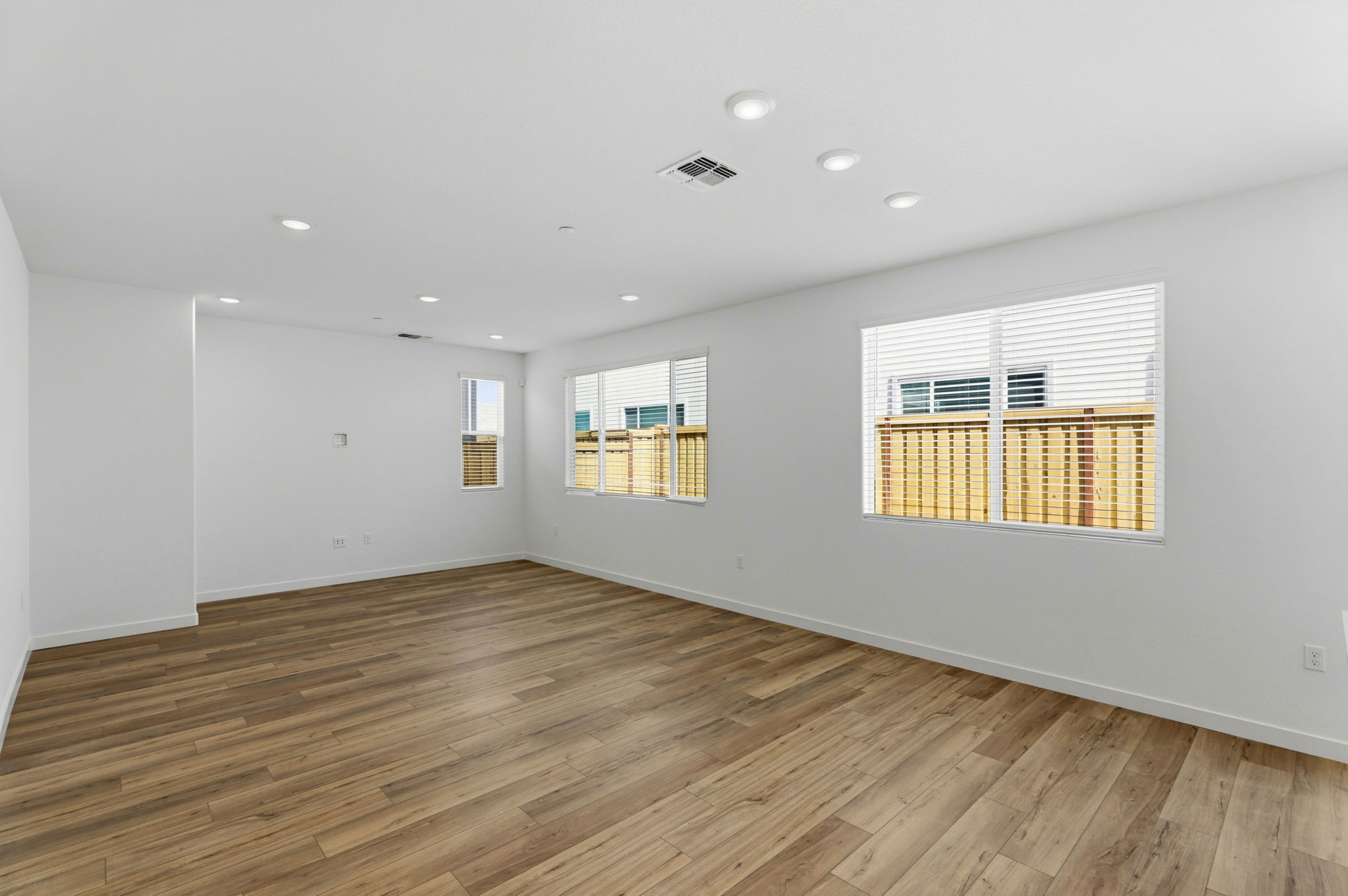 A room with a wood floor and windows.