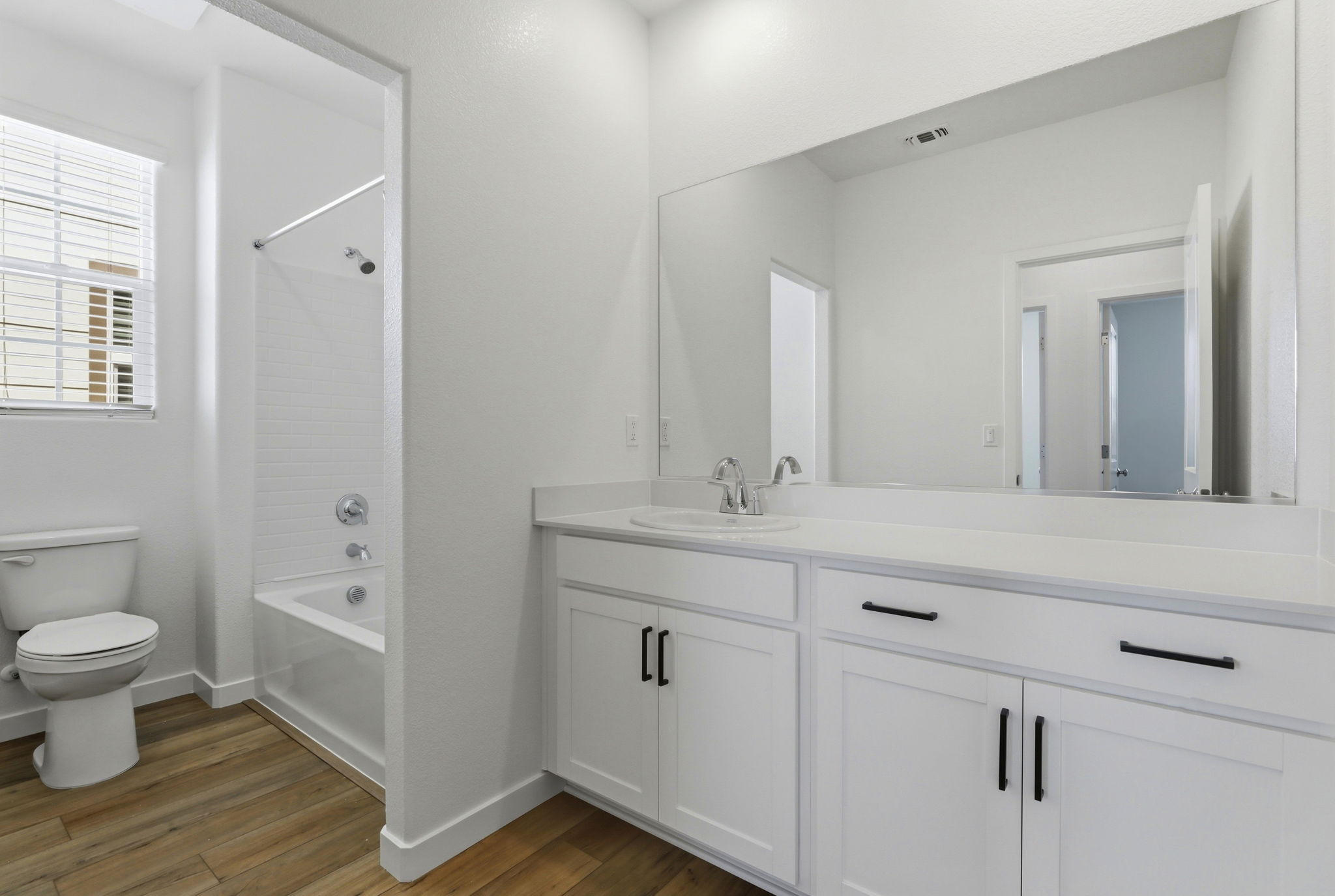 A bathroom with white cabinets.