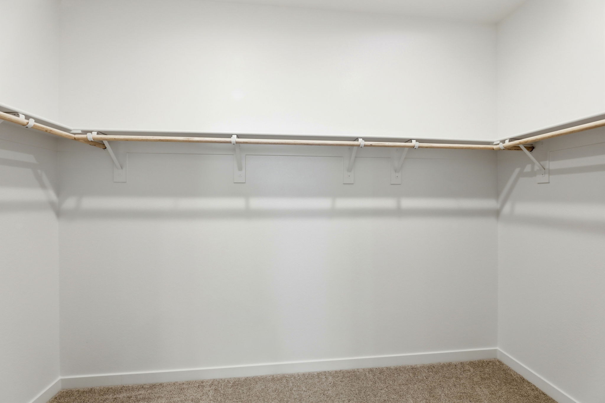A white wall with a metal bar.