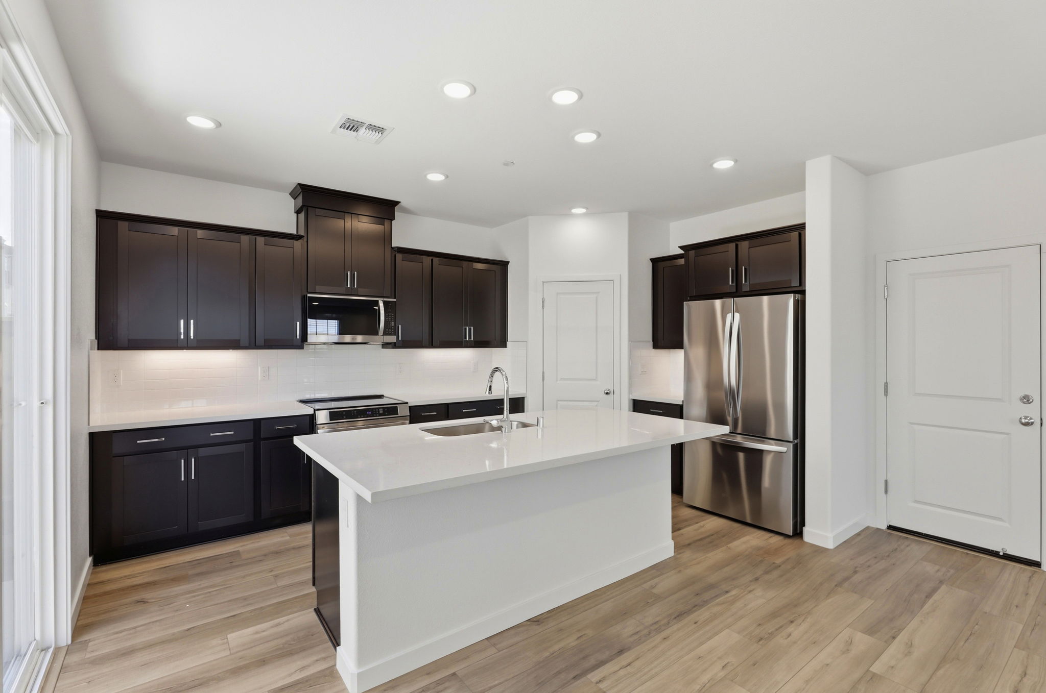 A kitchen with black cabinets.