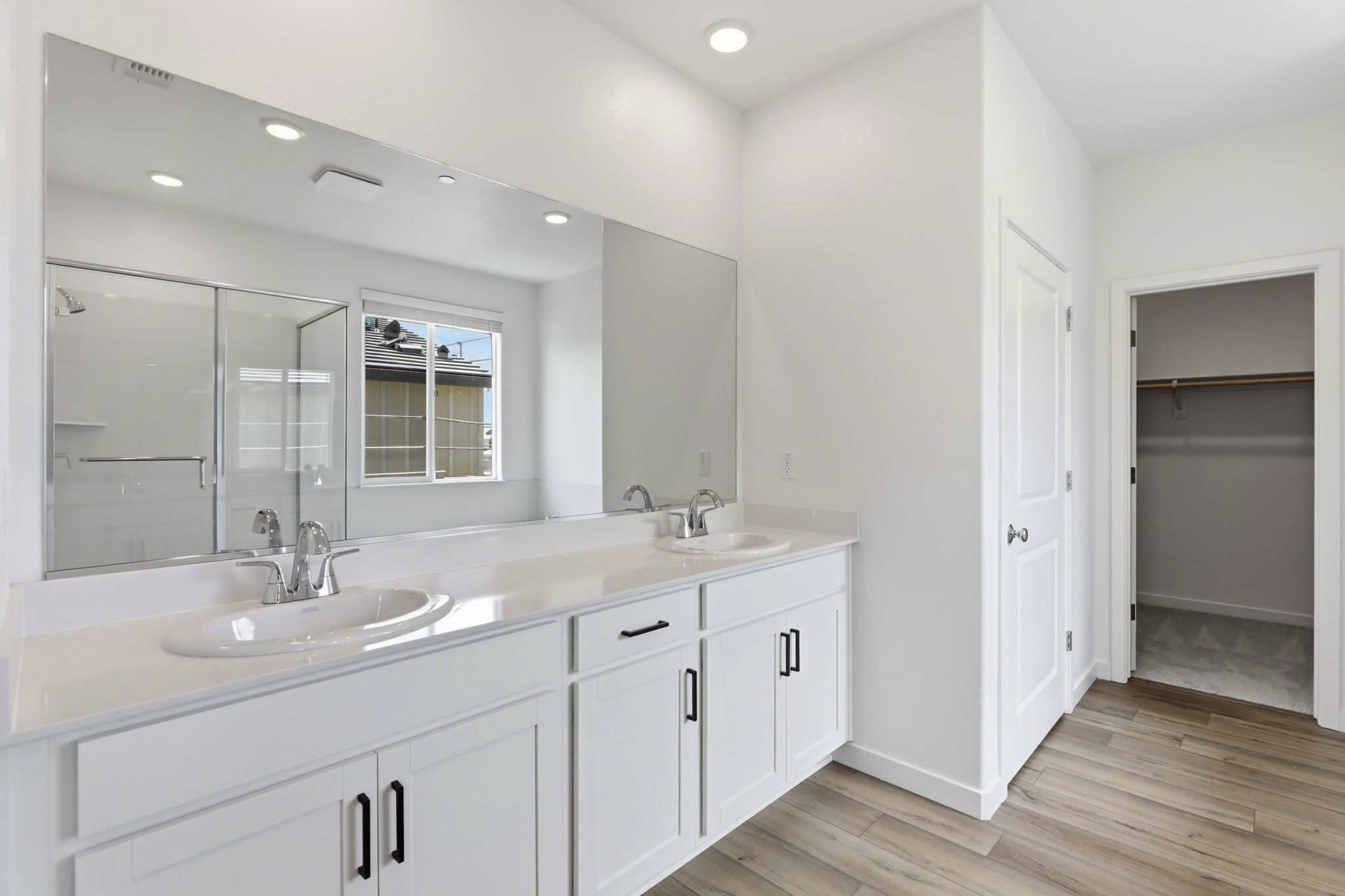 A bathroom with white cabinets.