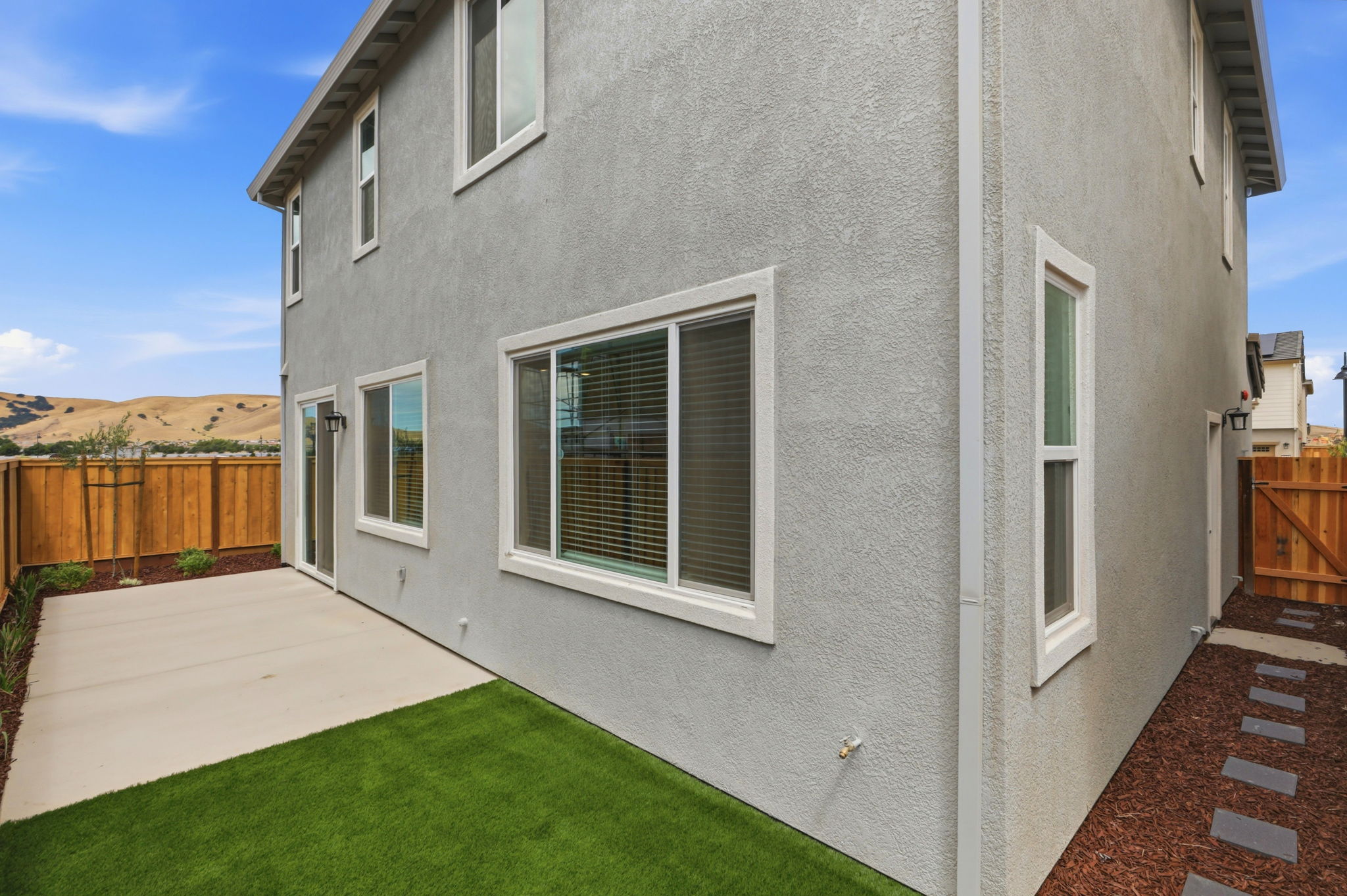 A grey house with a green lawn.
