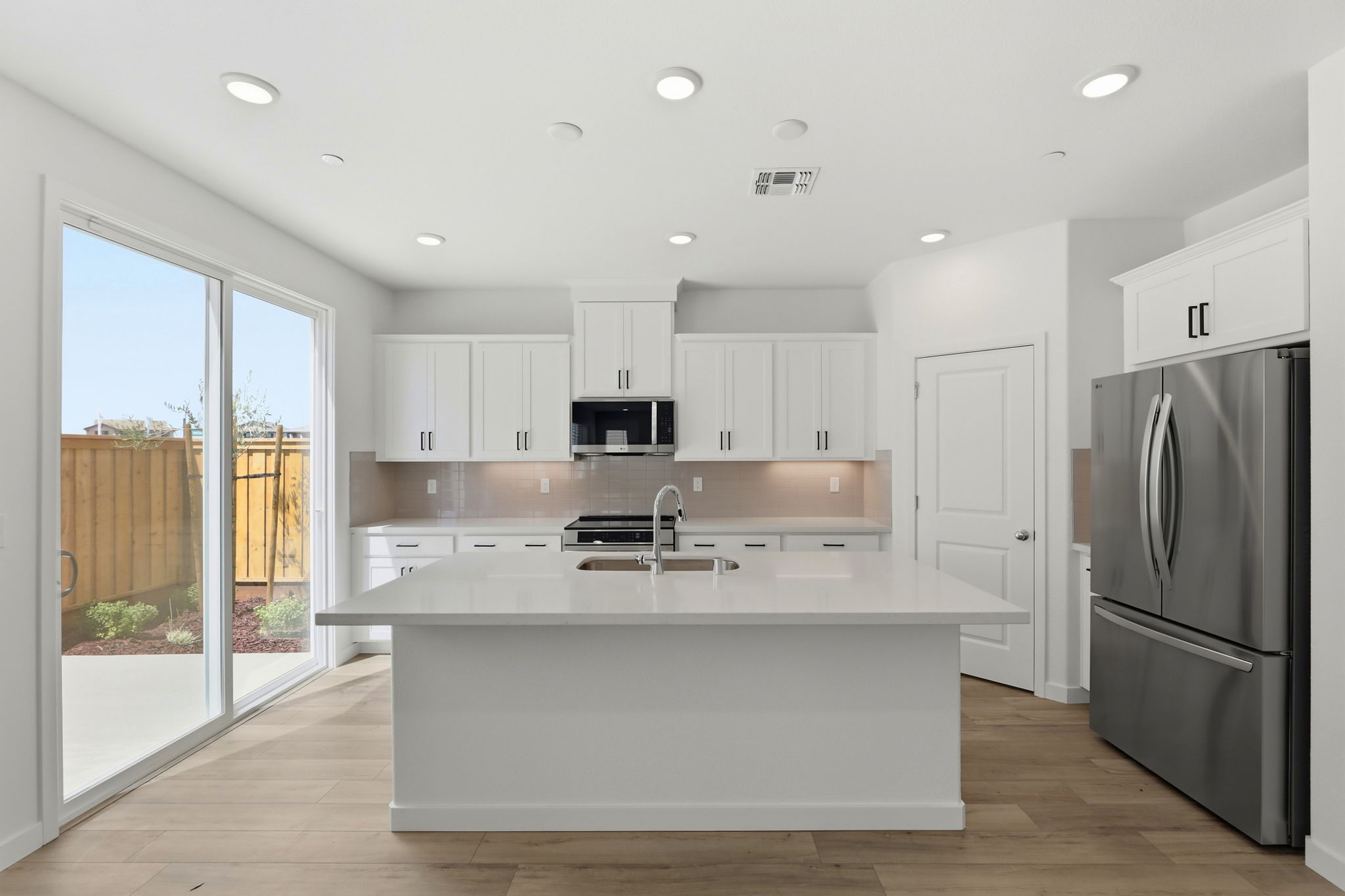 A kitchen with white cabinets.