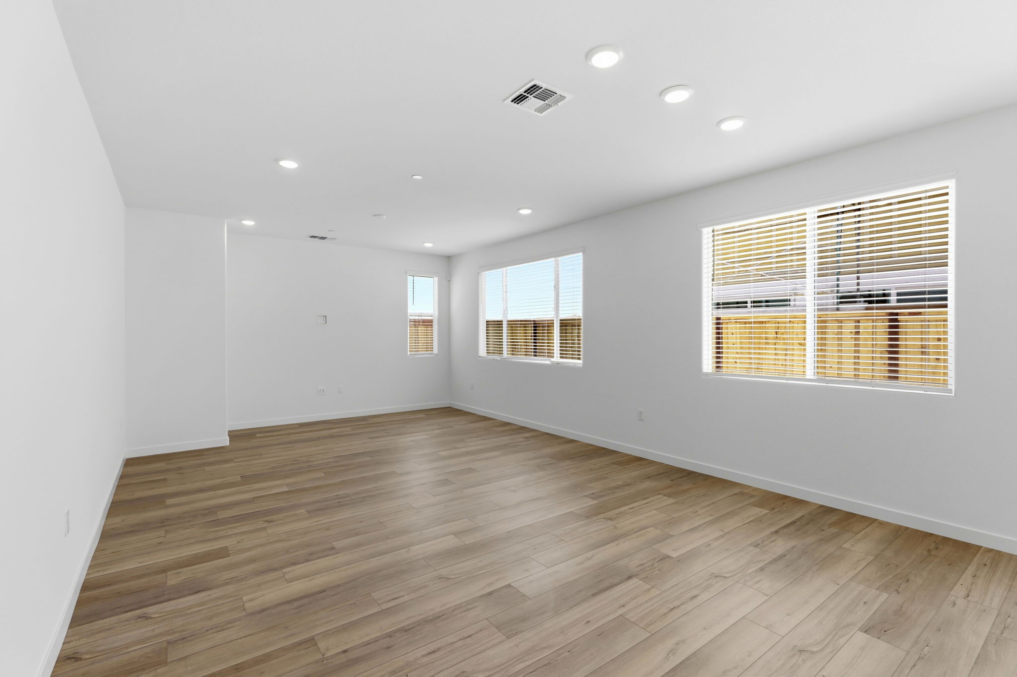 A room with a wood floor and windows.