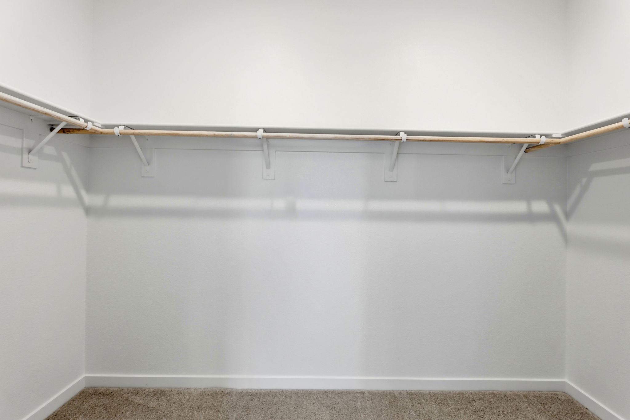 A white wall with a metal bar.