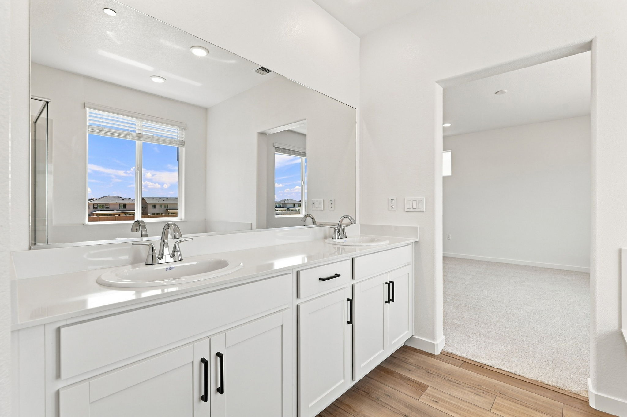 A bathroom with white cabinets.