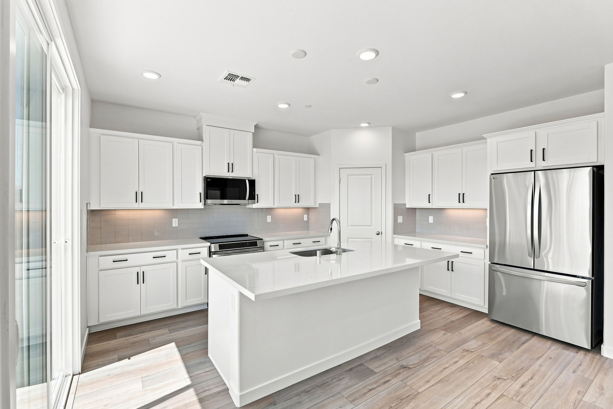 A kitchen with white cabinets.