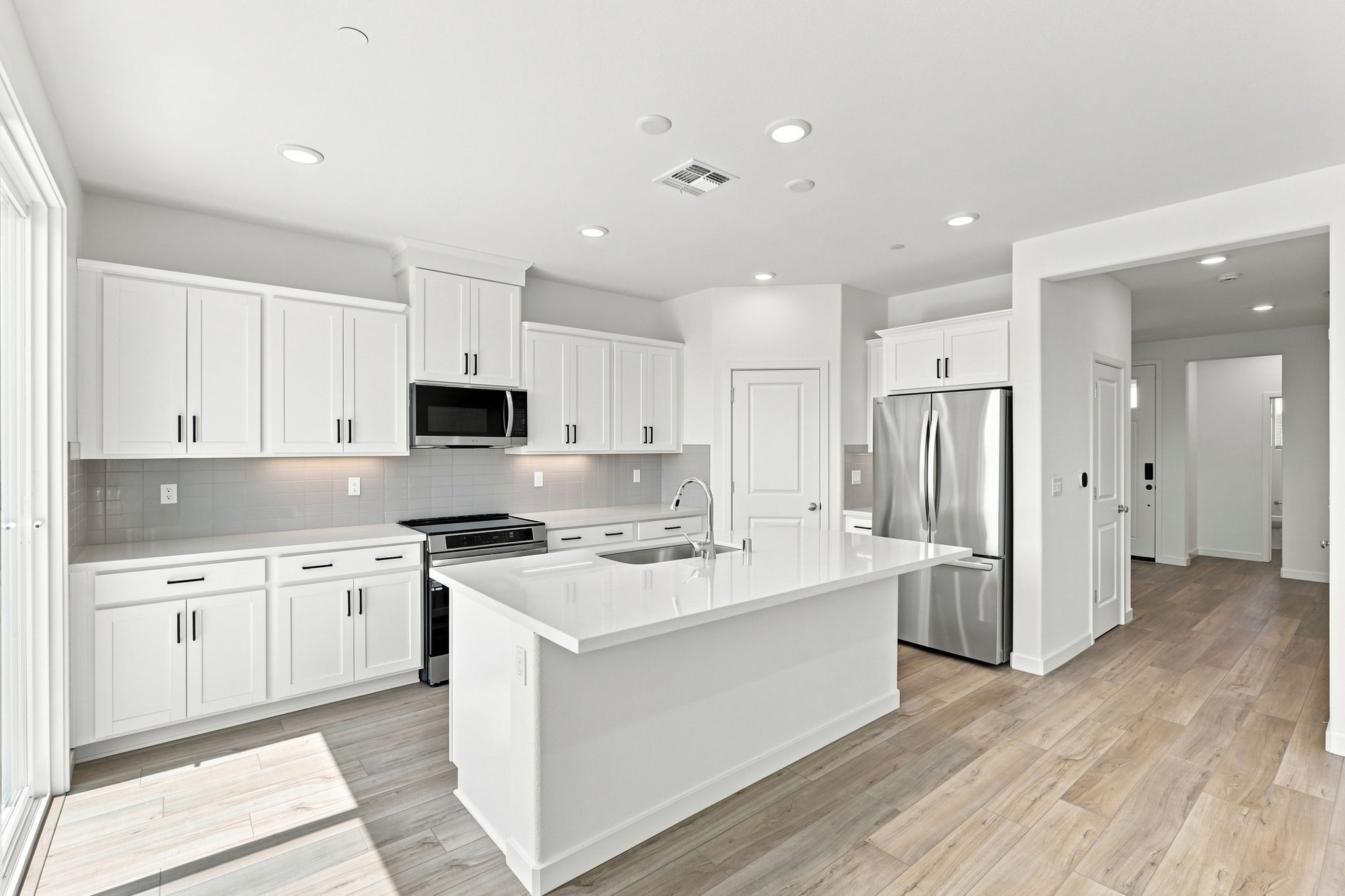 A kitchen with white cabinets.