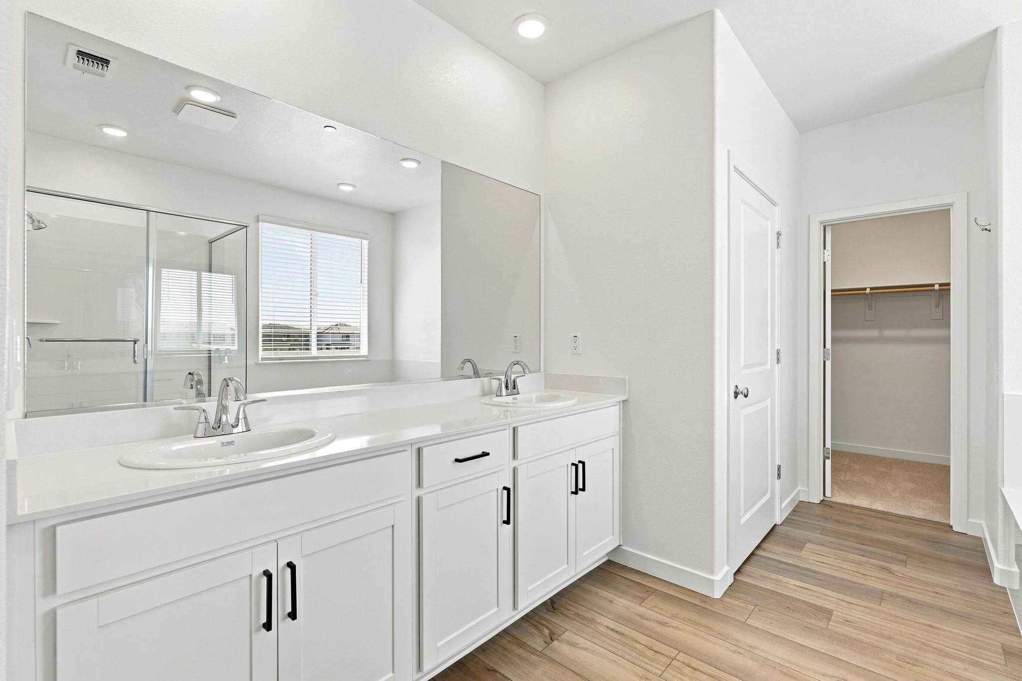 A bathroom with white cabinets.
