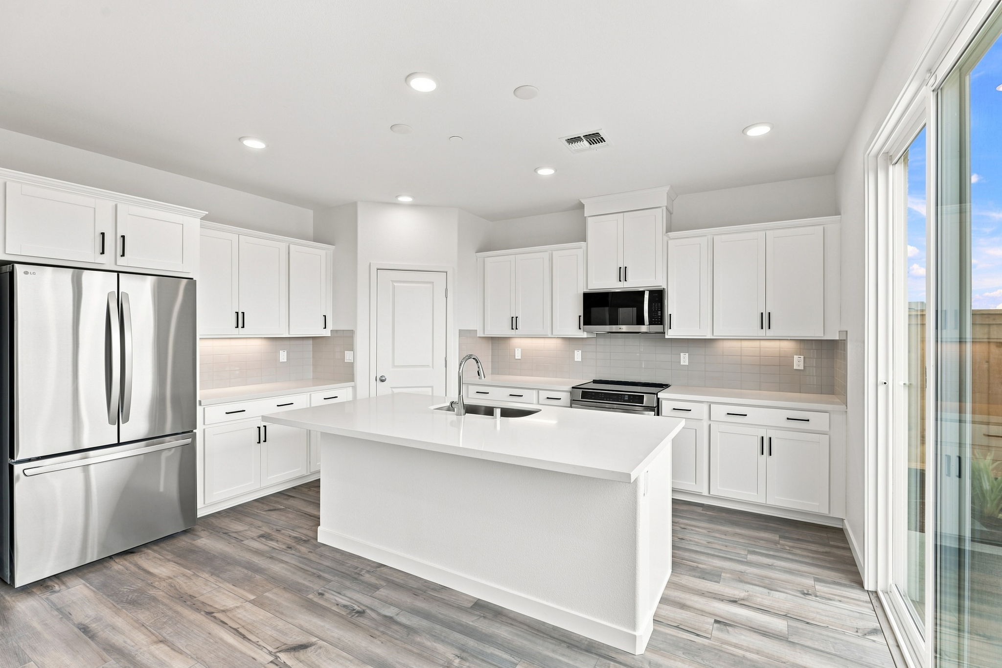 A kitchen with white cabinets.