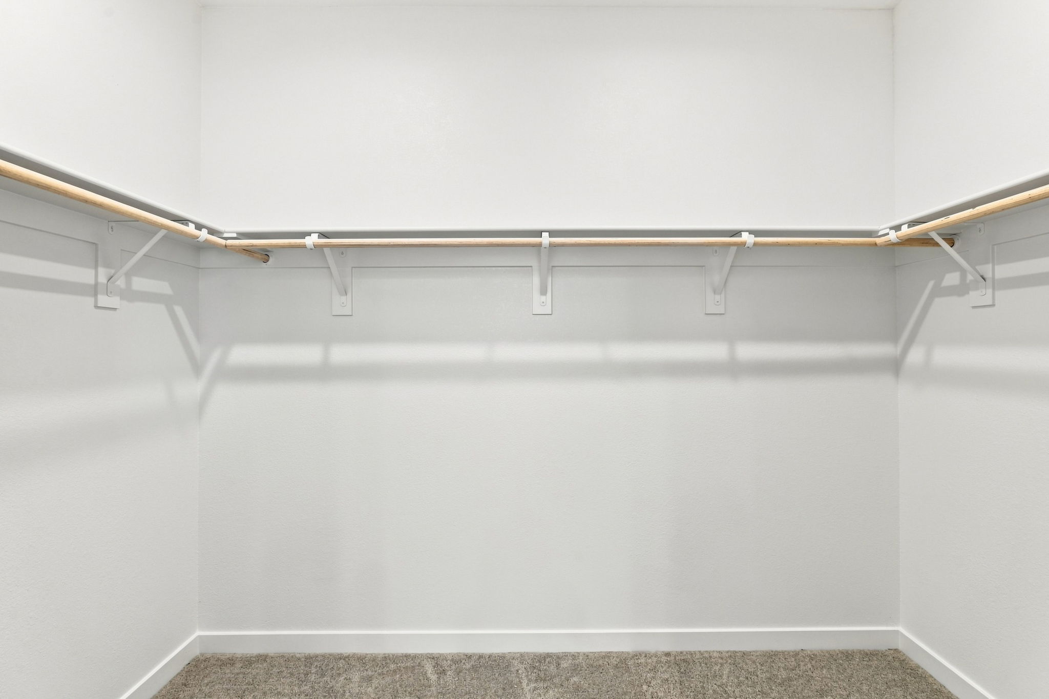 A white wall with a metal bar.