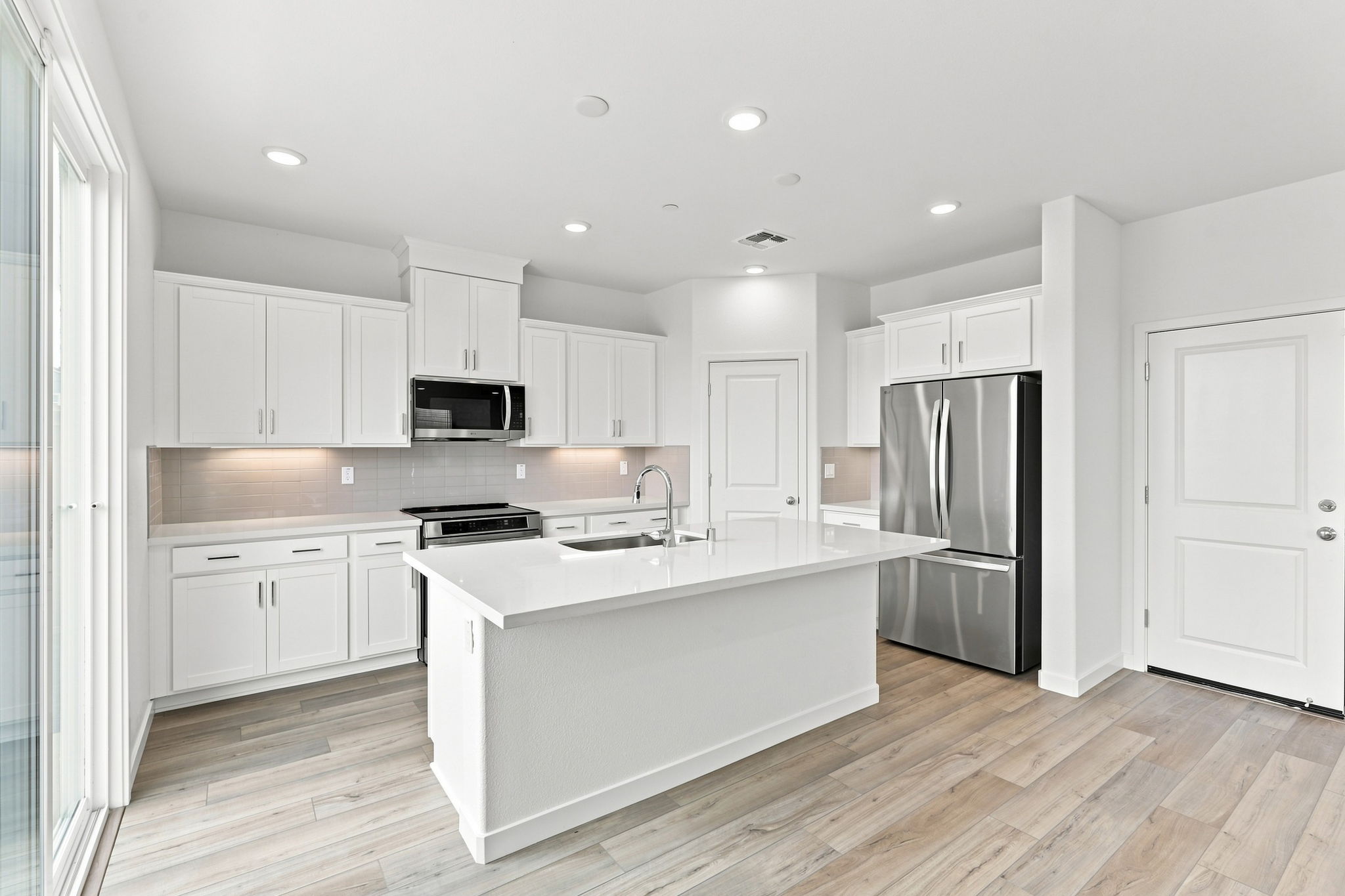 A kitchen with white cabinets.