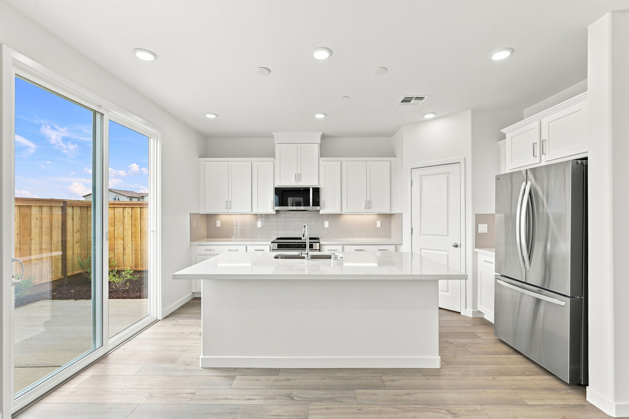 A kitchen with white cabinets.
