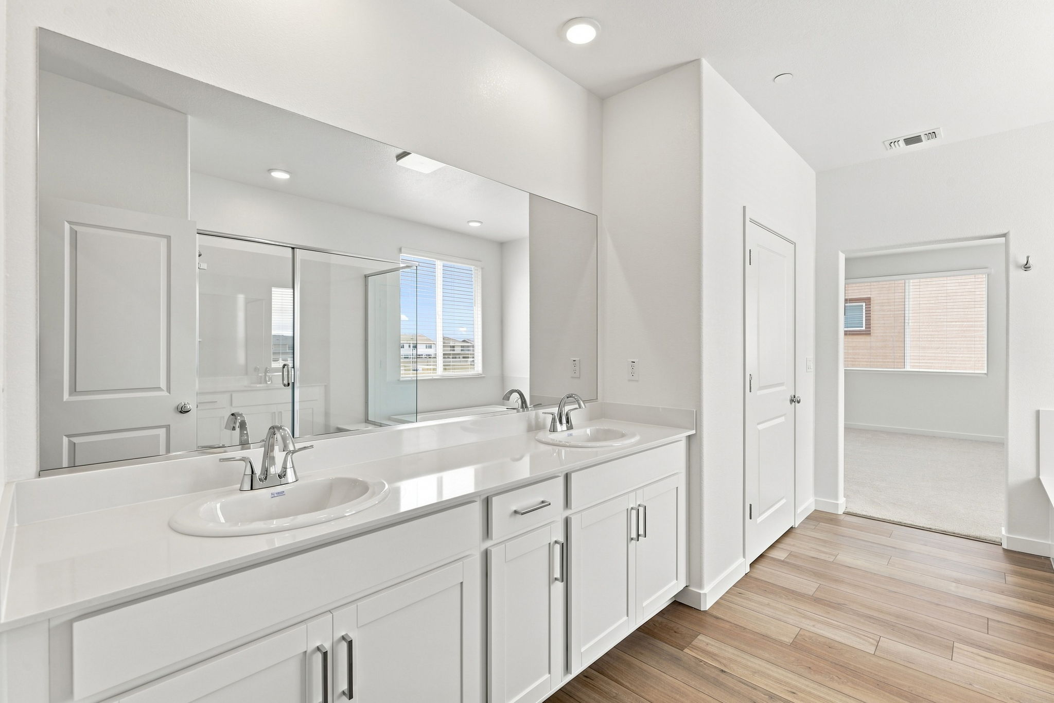 A bathroom with white cabinets.