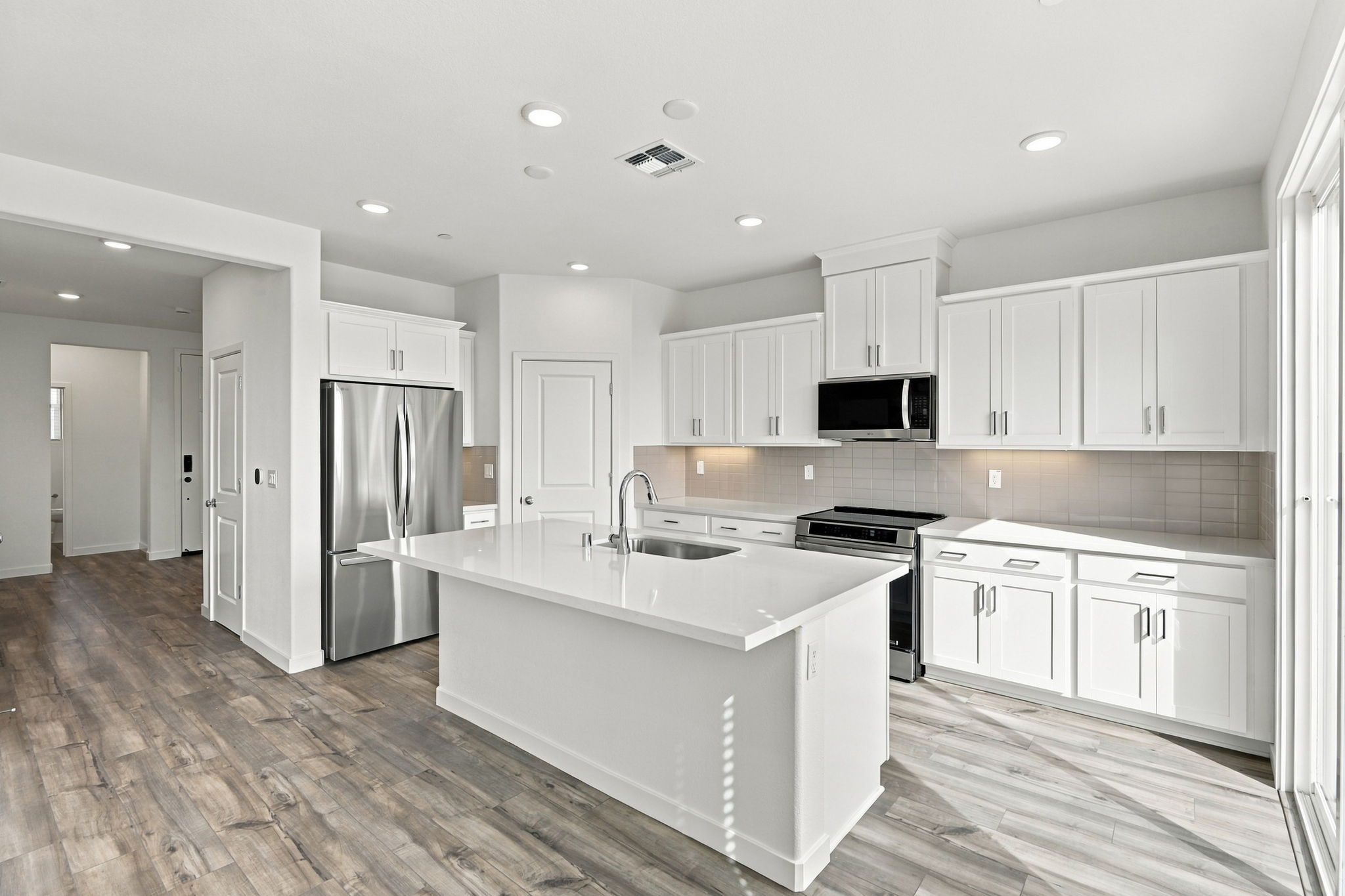 A kitchen with white cabinets.