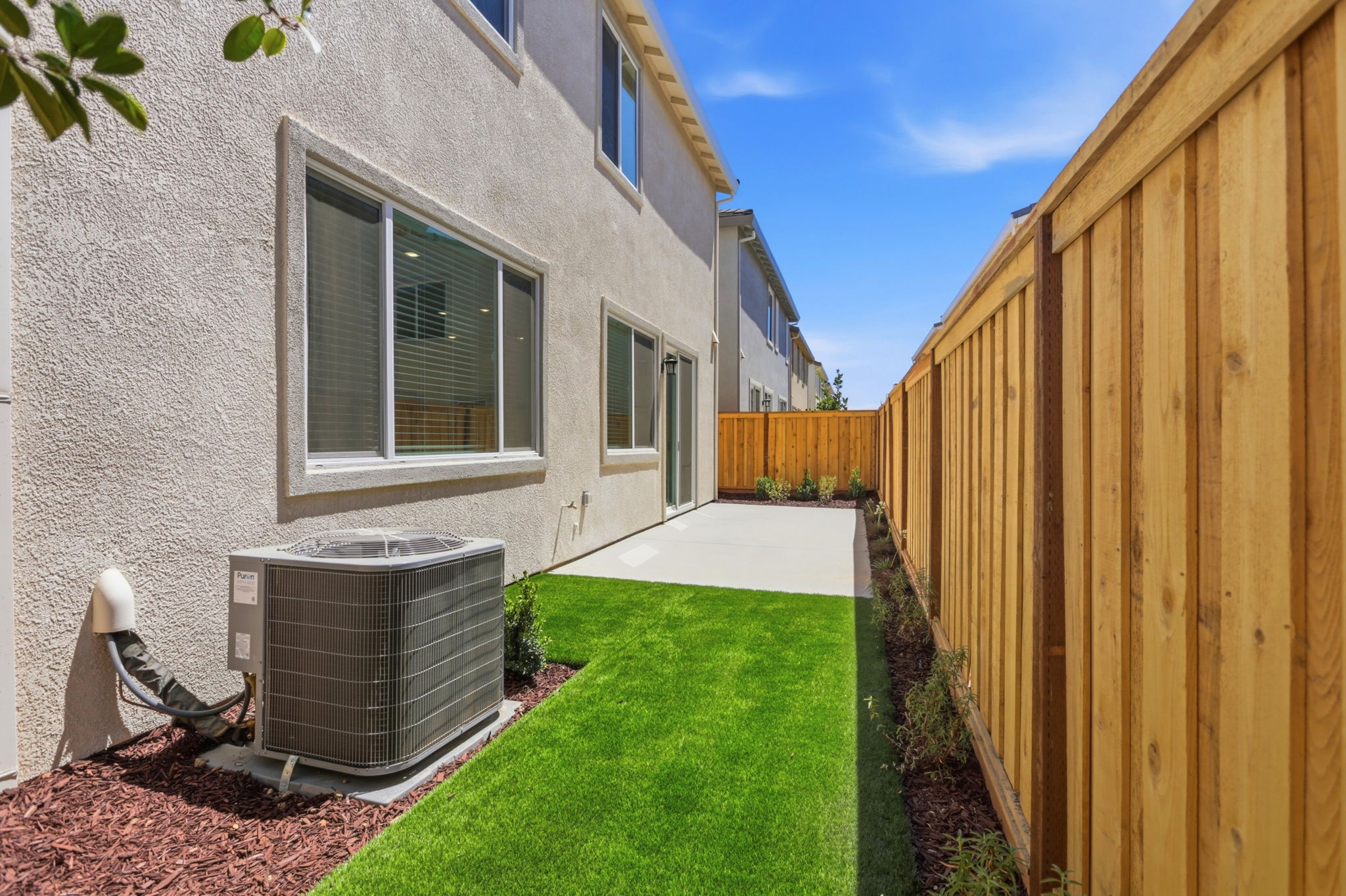 A backyard with a fence and a lawn.