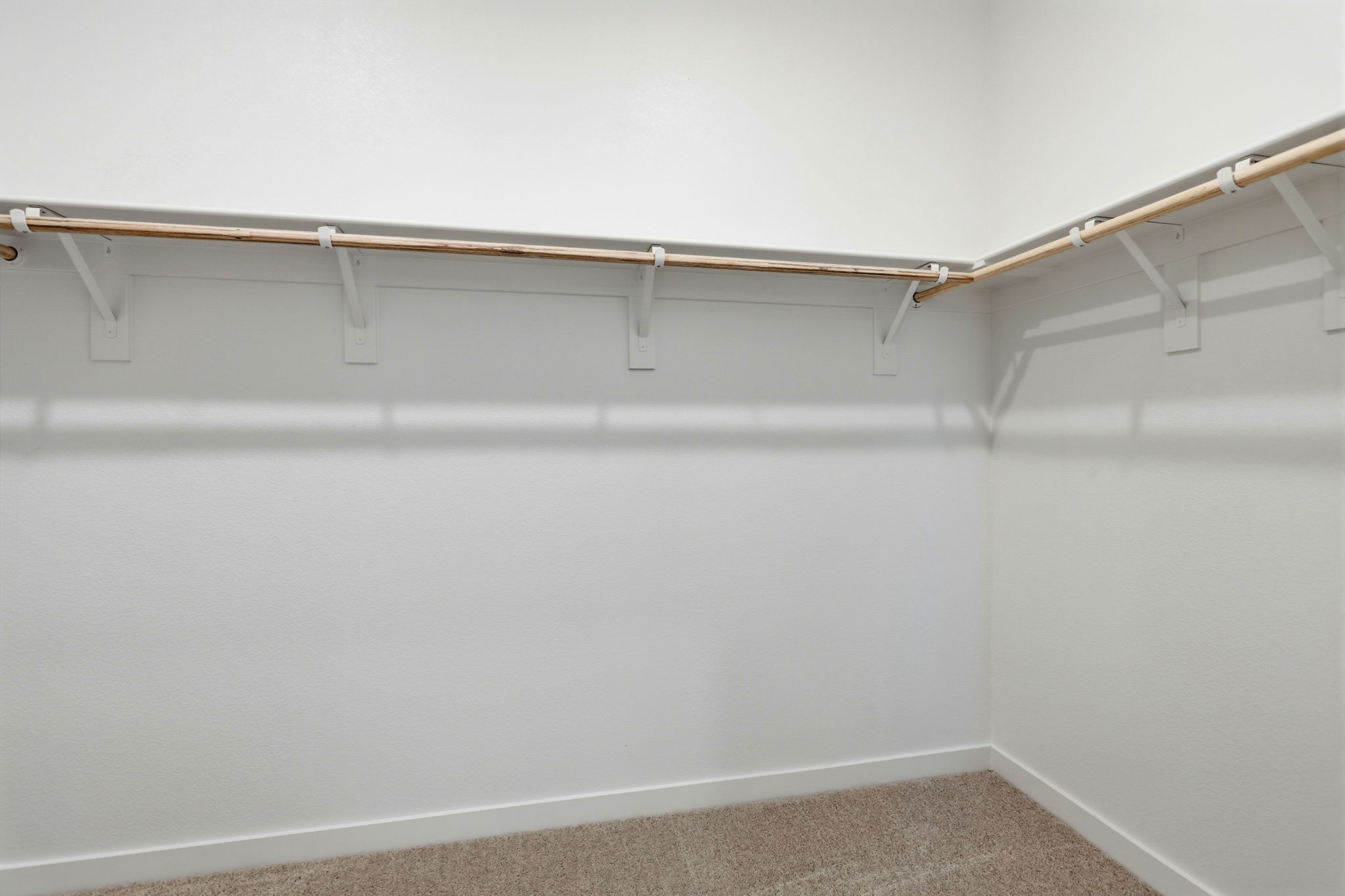 A white wall with a metal bar.