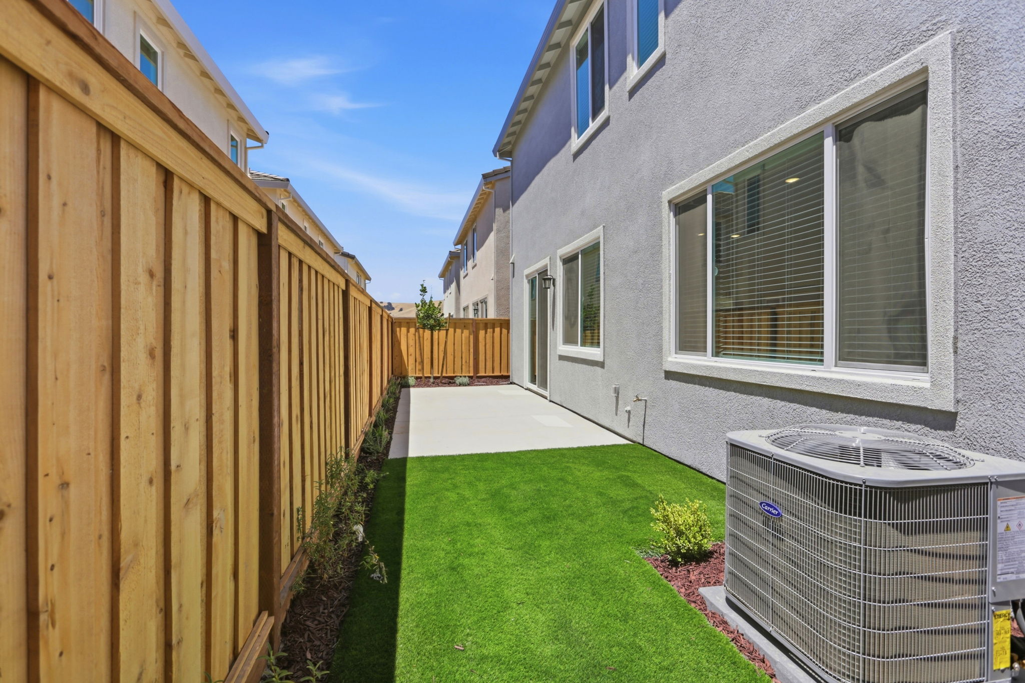 A backyard with a fence and a house.