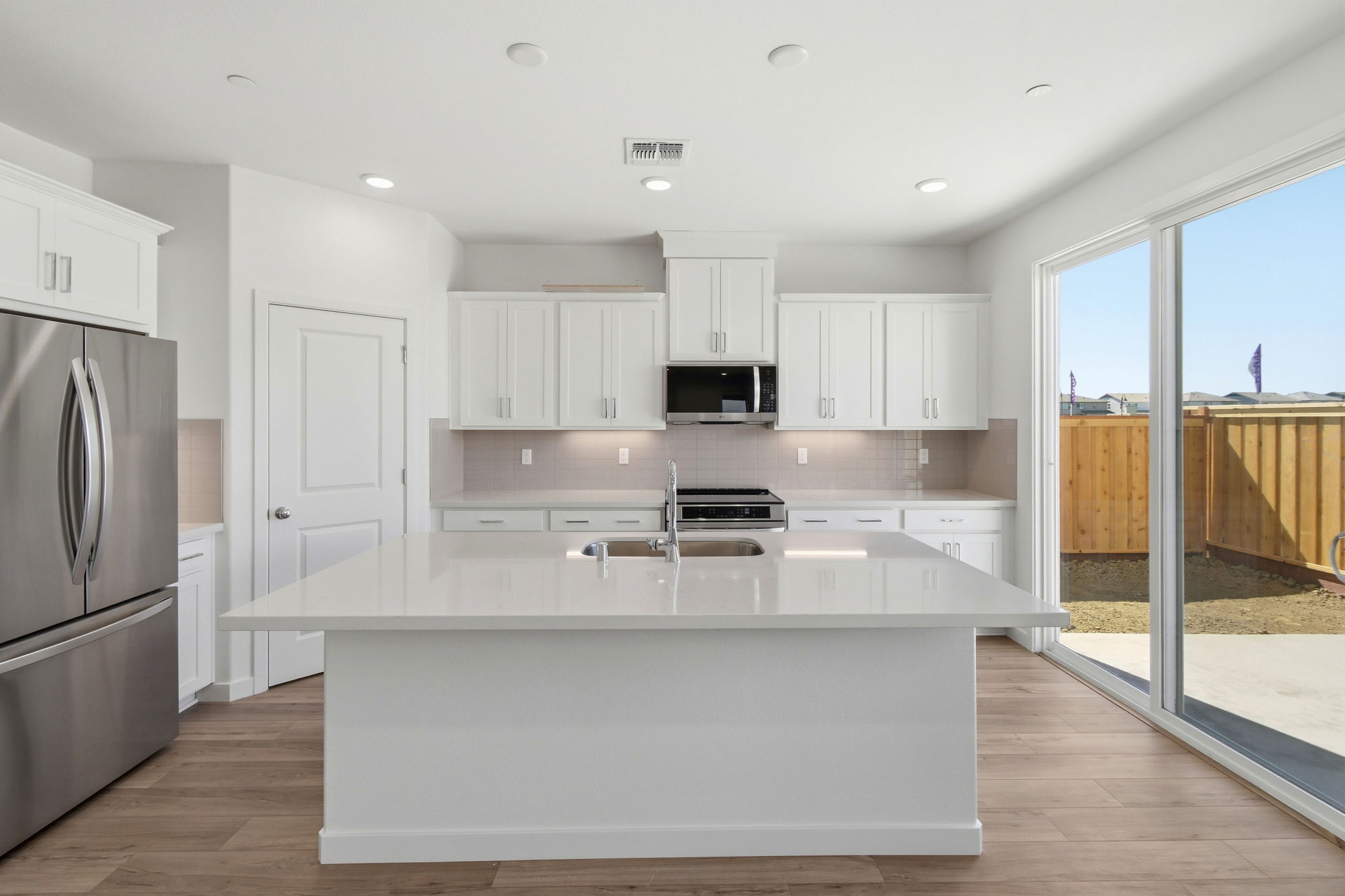 A kitchen with white cabinets.